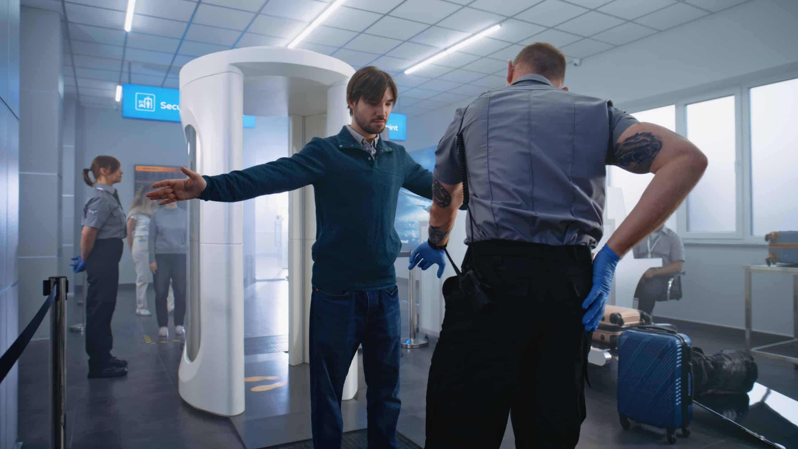 Airport Terminal Security Check: Adult Man, Tourist Passes Through Metal Detector Scanner Gates. Security Officer Checks Passenger for Boarding Plane Flight. Diverse Travelers Going on Holiday Trips.