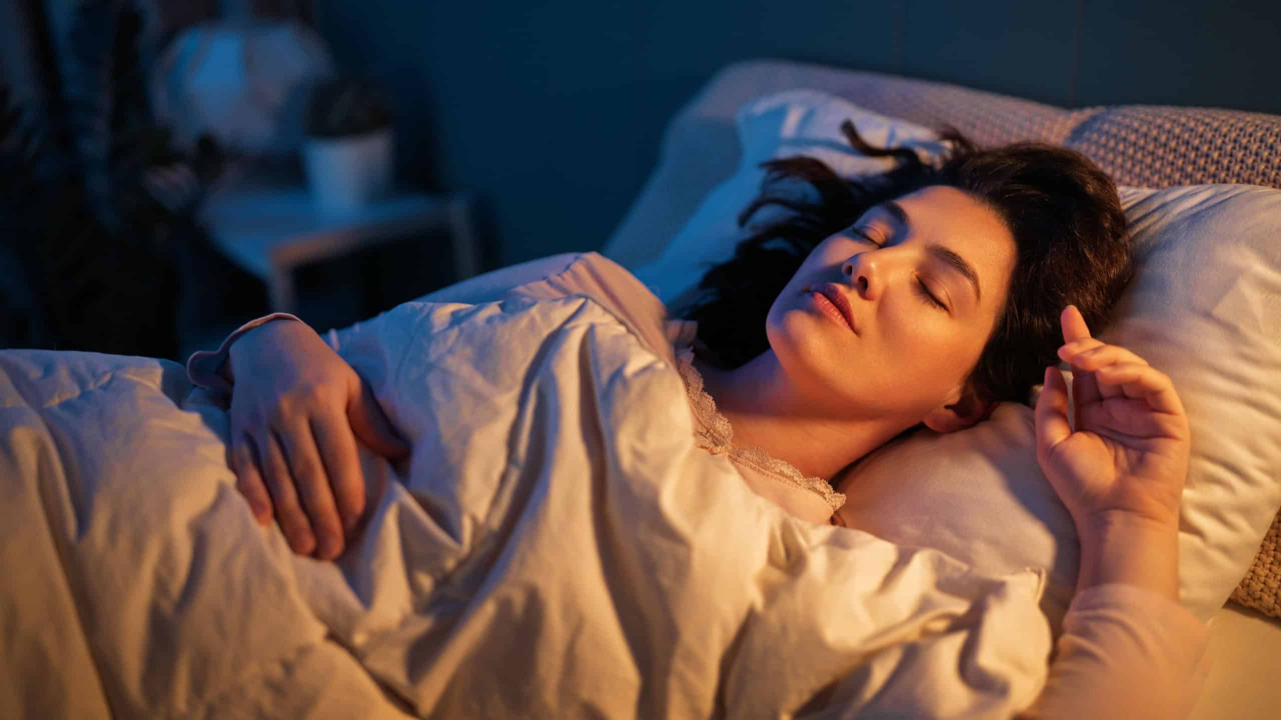 Woman is sleeping peacefully in her bedroom at night.