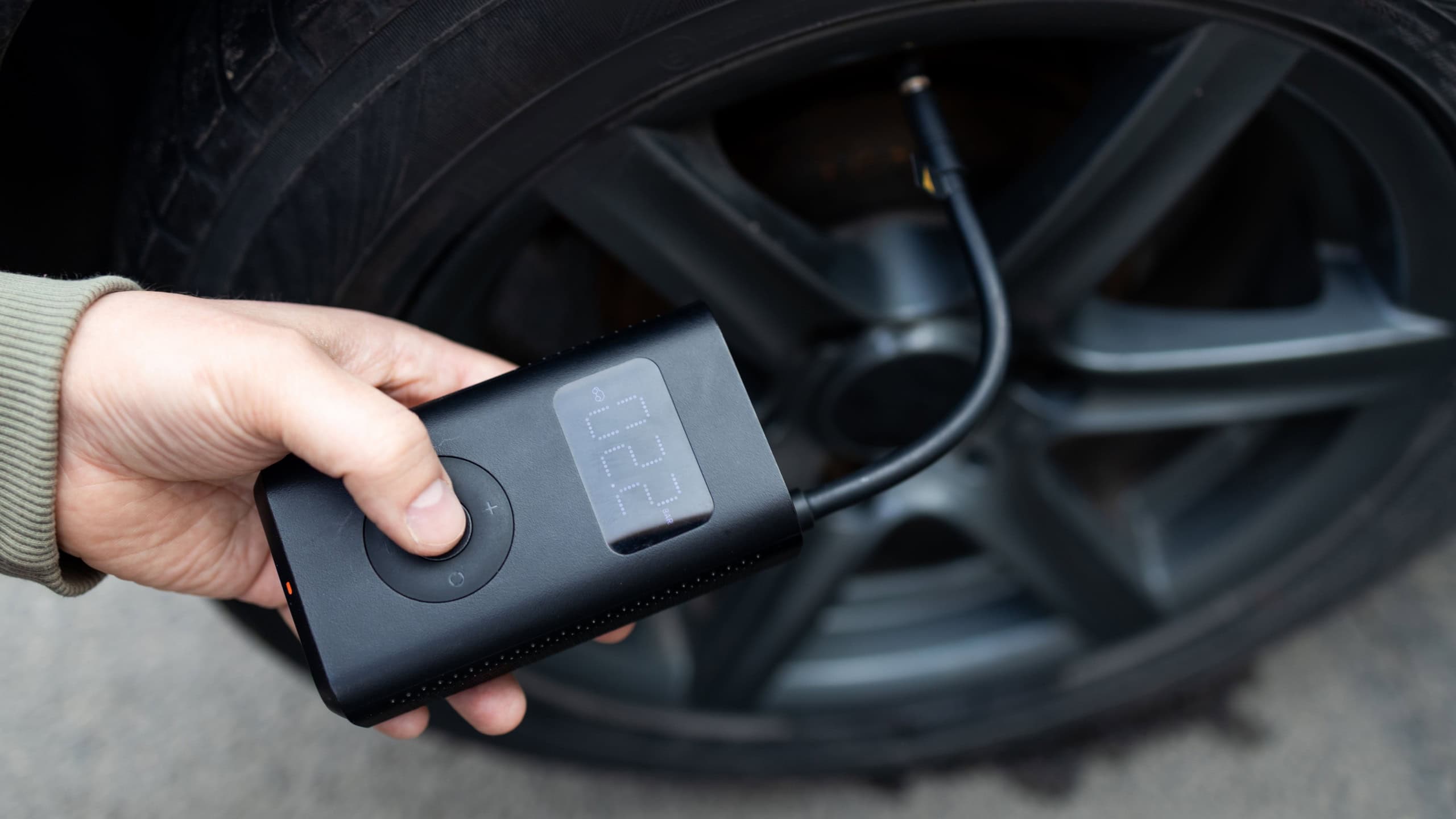 man driver hand inflating tires of vehicle, removing tire valve nitrogen cap for checking air pressure and filling air on car wheel at gas station. self service, maintenance and safety. High quality