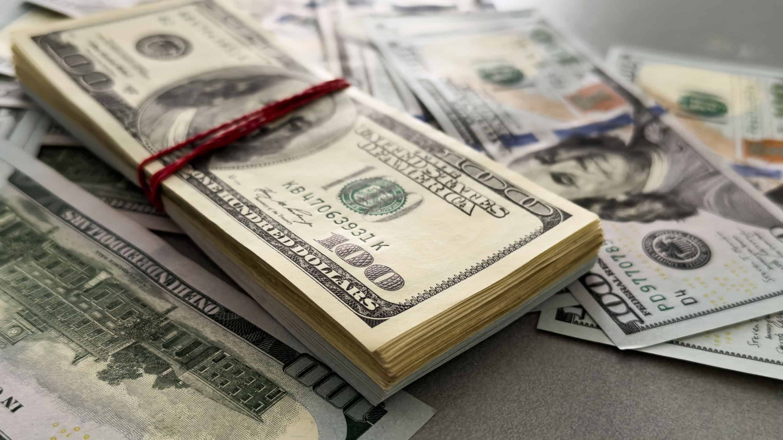 Pile of US 100 dollar banknotes on dollars background