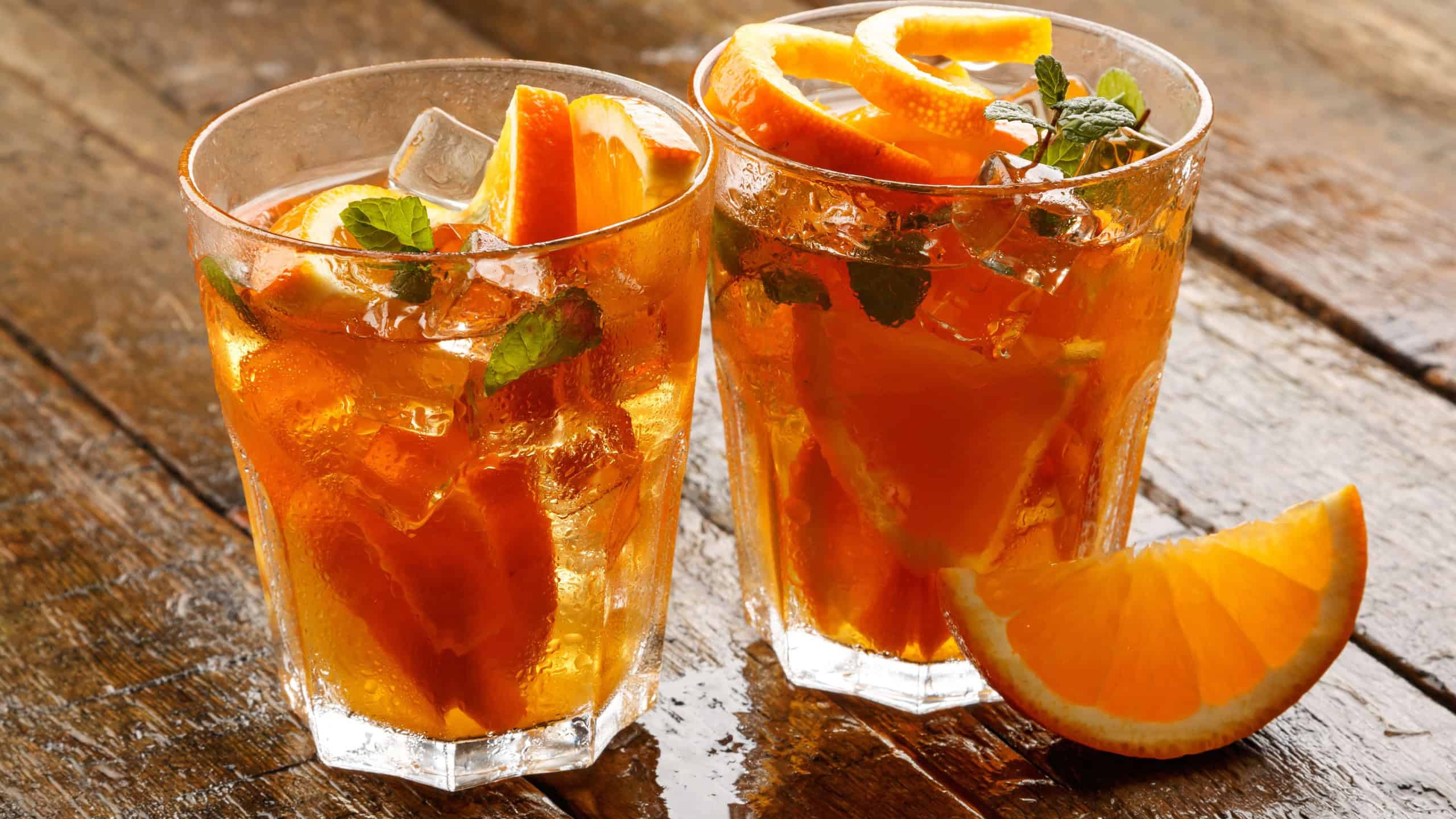 Refreshing lemonade with oranges and mint on wooden table