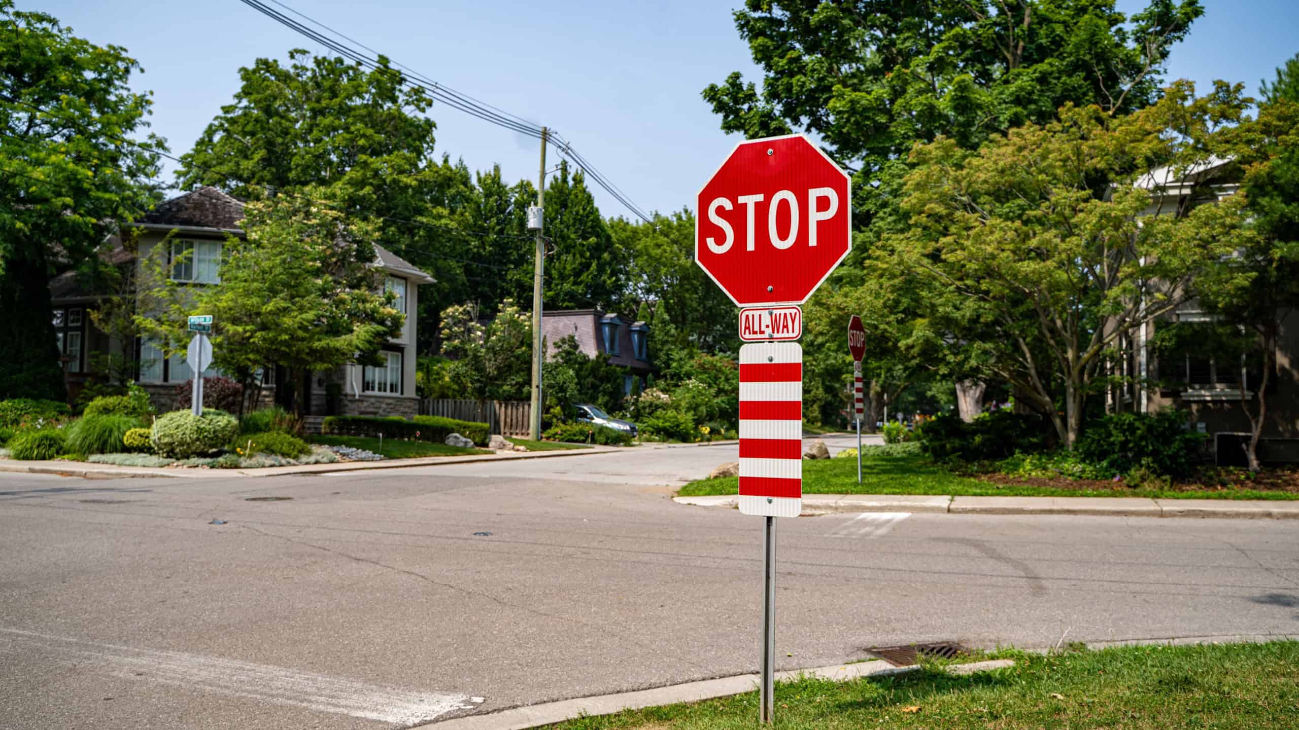 View of stop all way warning sign on roadside.