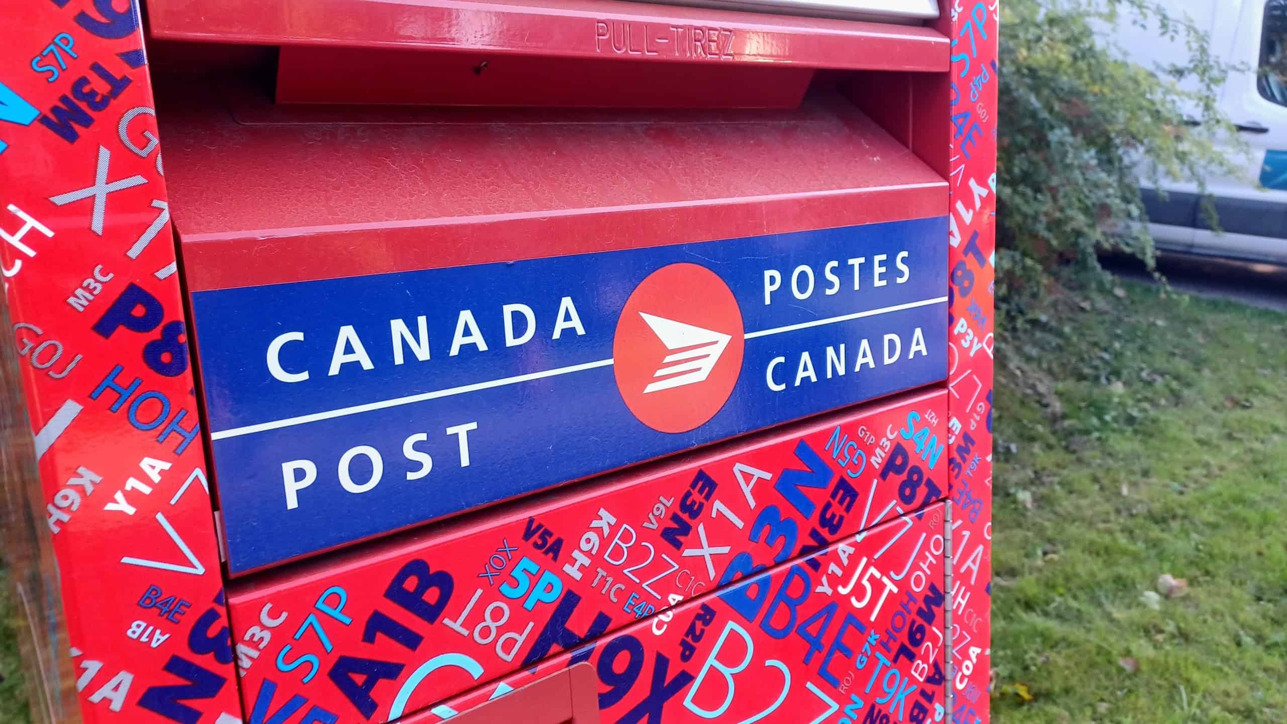 lose-up view of a Canada Post mailbox with red and blue design and bilingual Canada Post logo