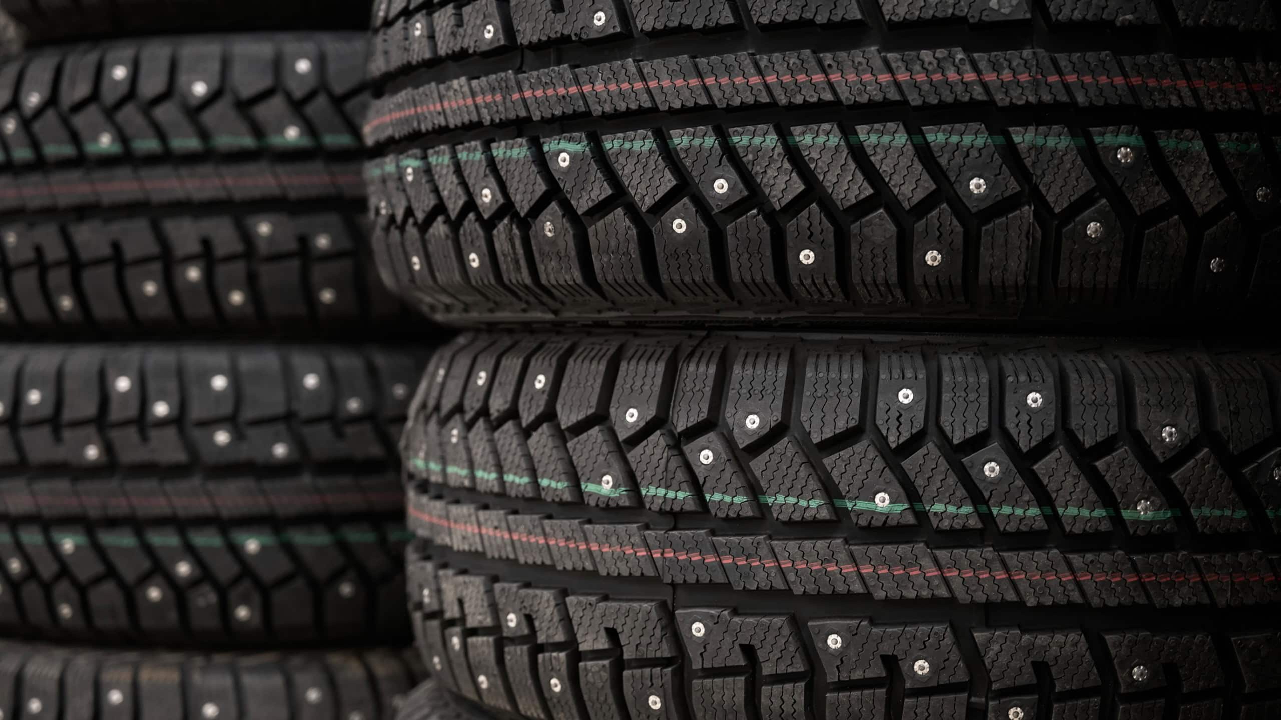Close-up of many new studded winter tires in market. Driving safety in winter conditions.
