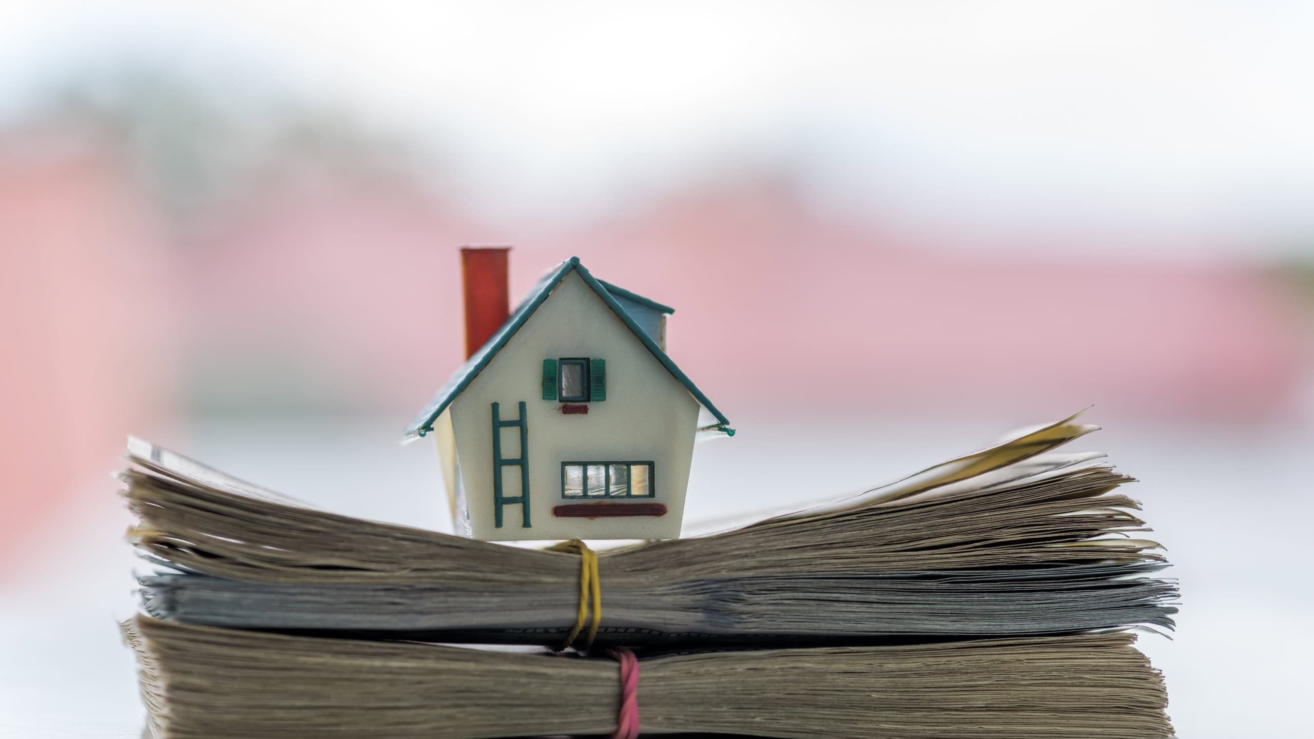 House model on dollar cash stack closeup