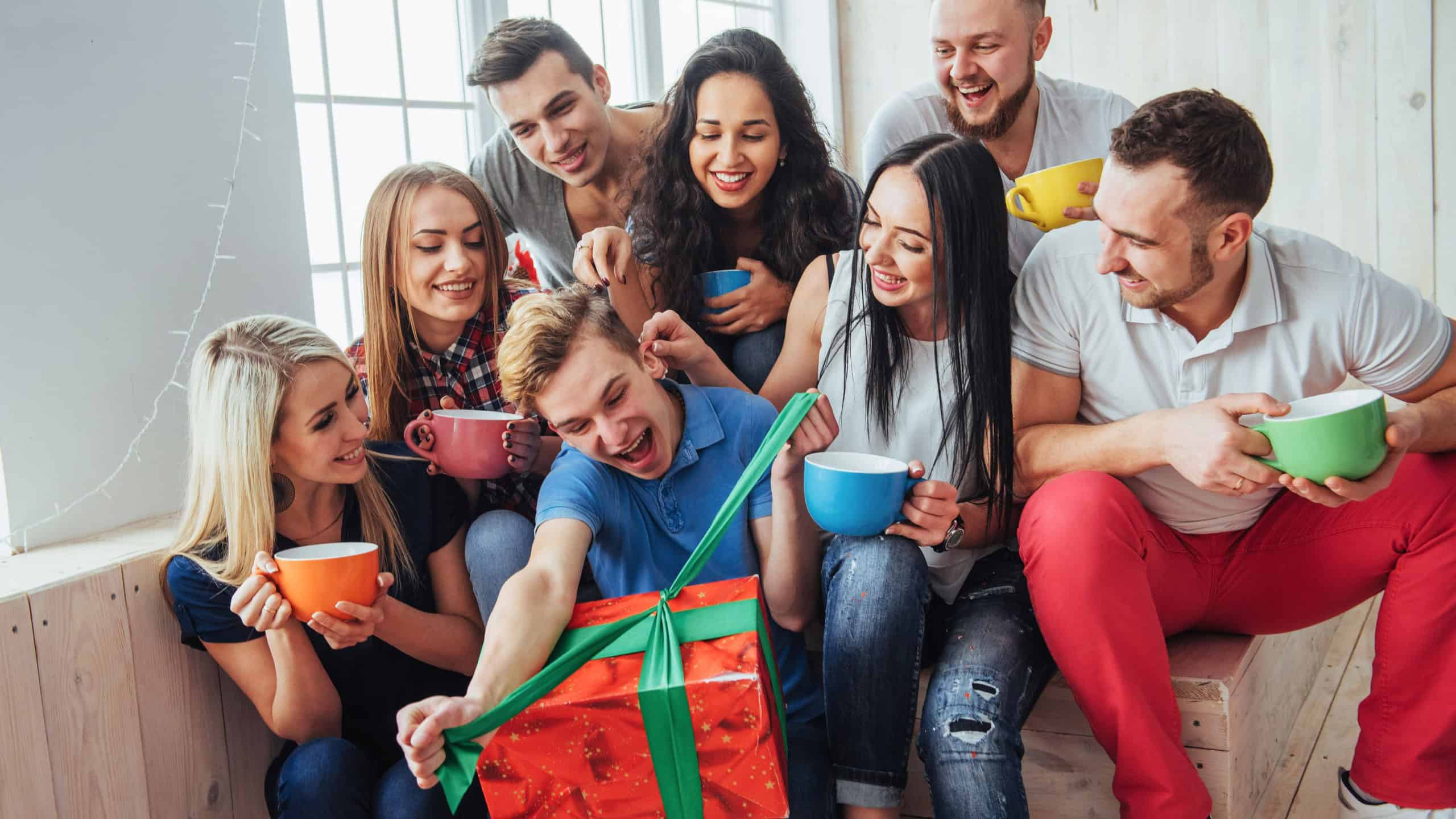 Group of best friends at party. smiling and cheerful people sitting on the stairs and a cup of coffee and greet the birthday, a great gift.