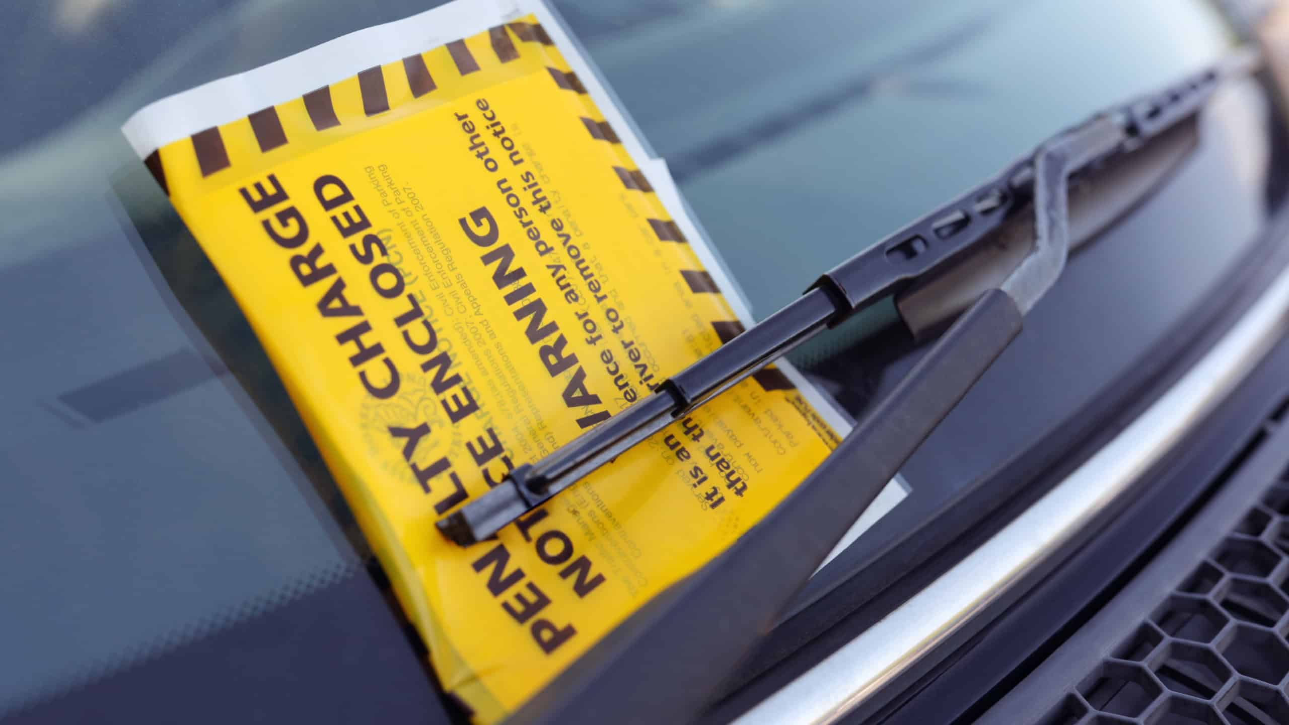 Penalty charge notice parking fine attached to car windscreen