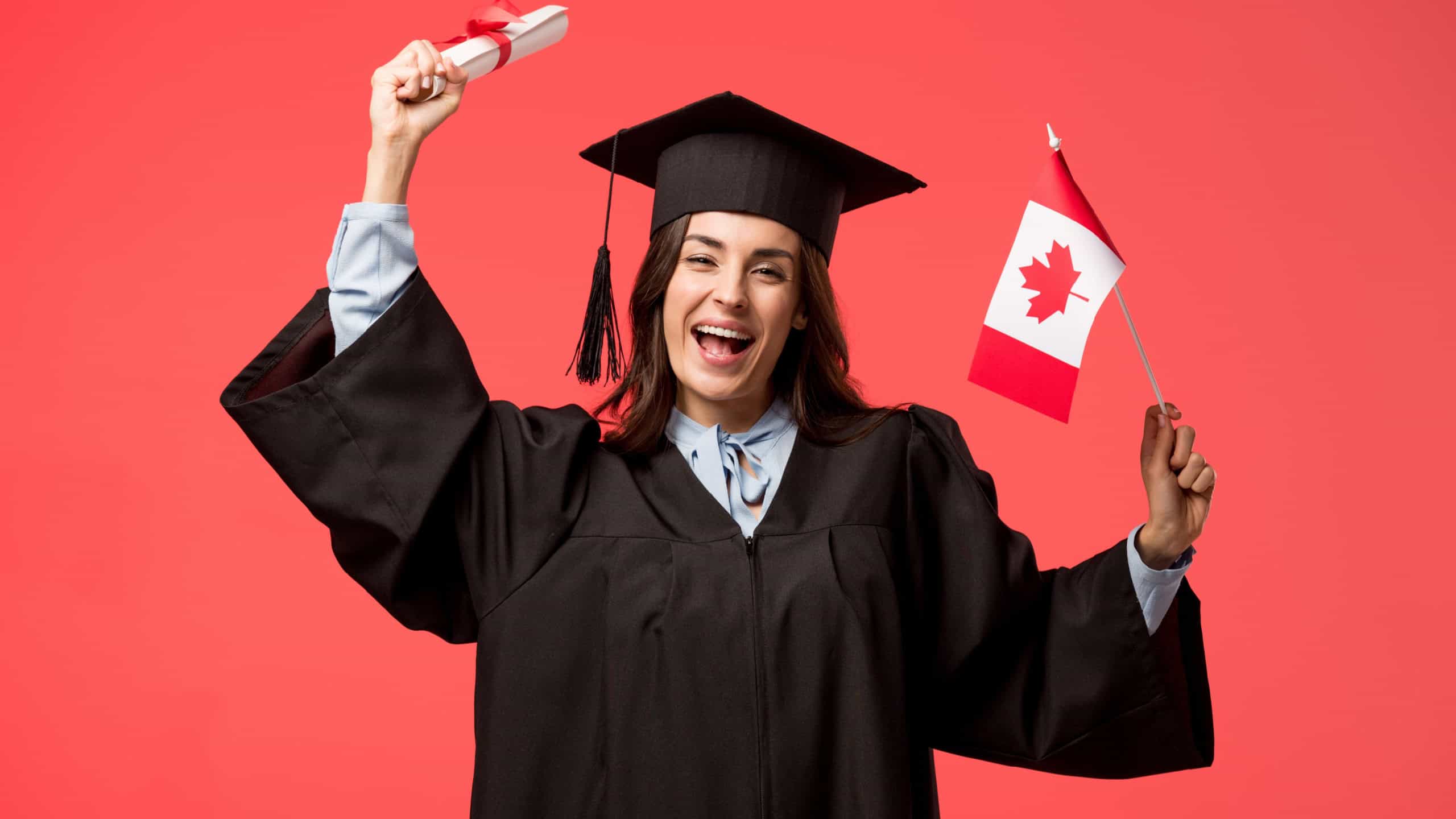 female student in academic gown holding canadian flag and diploma isolated on living coral