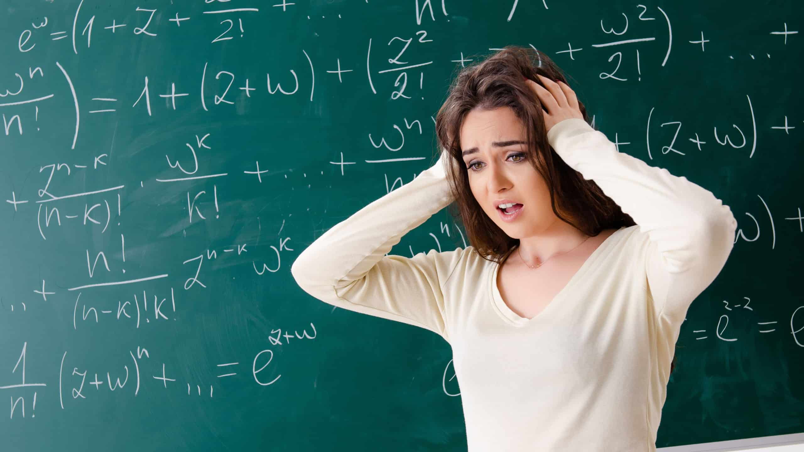 Young female math teacher in front of chalkboard