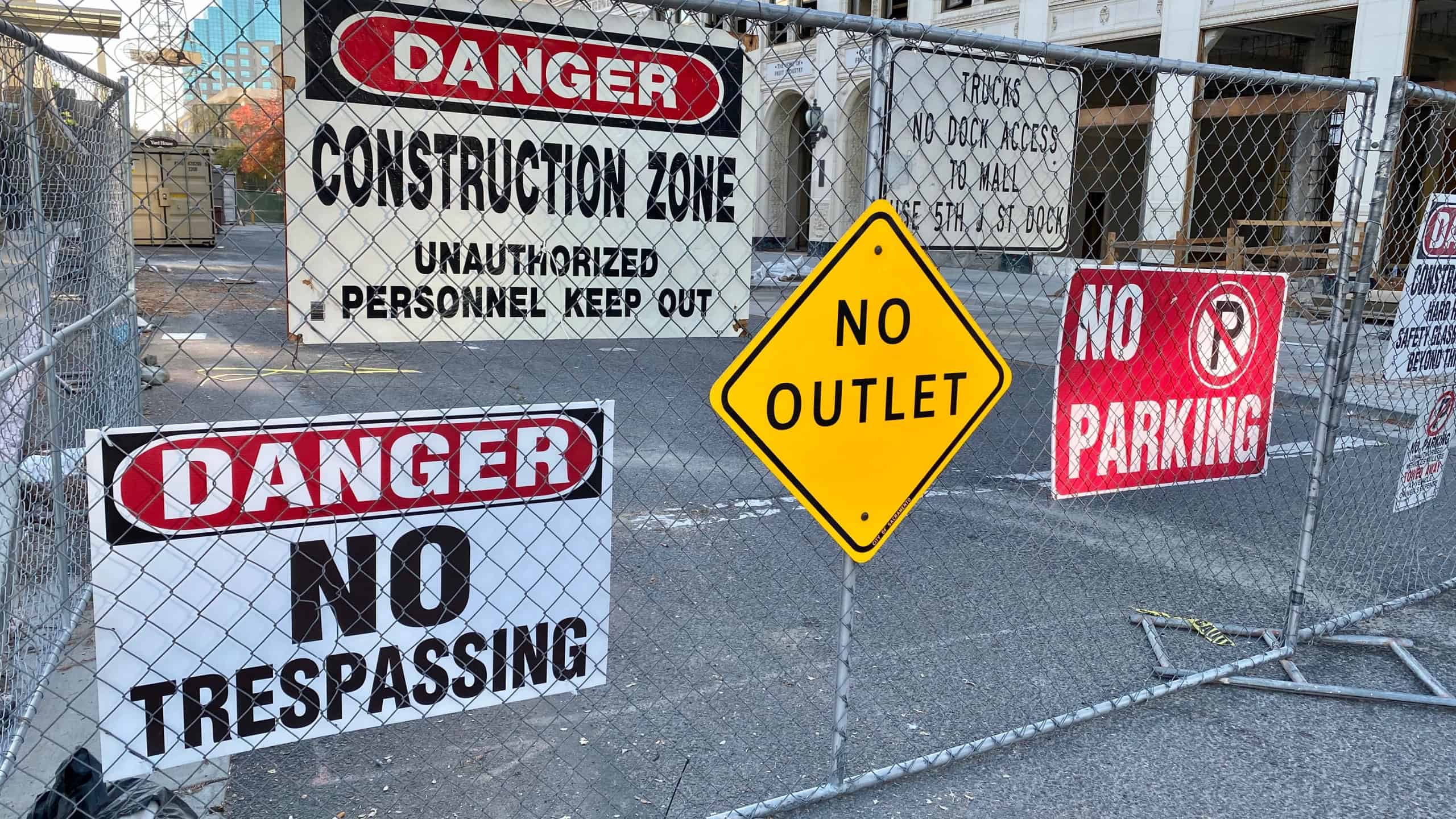 Sacramento, CA - November 8, 2019: Fence with lots of caution, warning and danger signs near a construction site. 