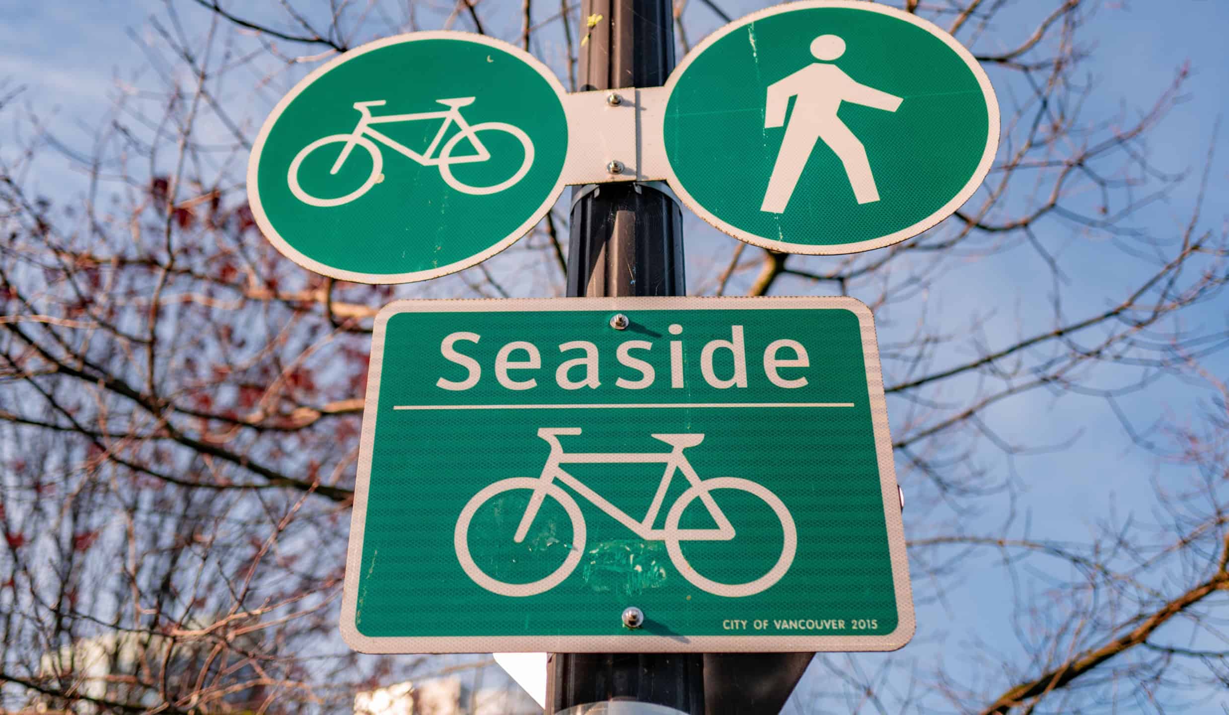 VANCOUVER, CANADA - Nov 13, 2019: Low angle view of sign on Coal Harbour Seawall in Vancouver, BC. Gives information of pedestrian and cycle path