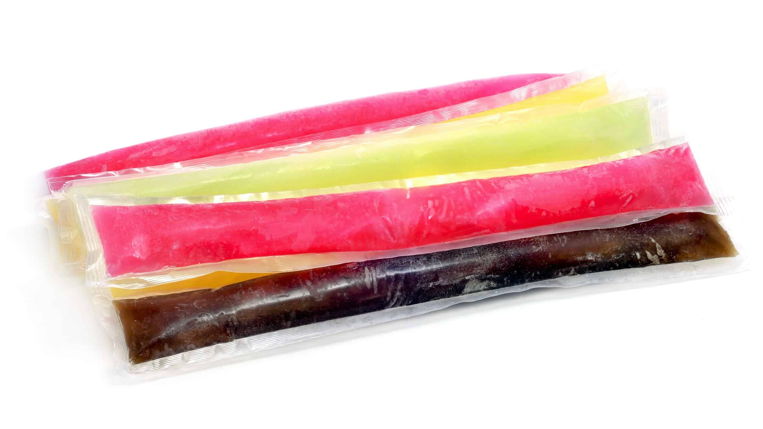 some freezies of different colors and flavors on a white background
