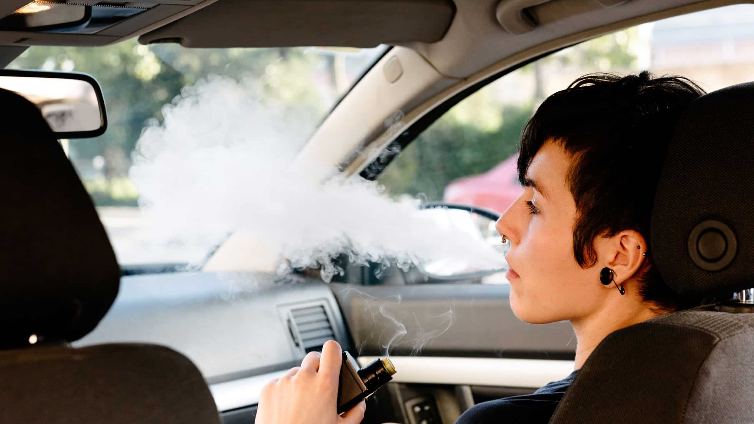 Young woman smoking inside a car