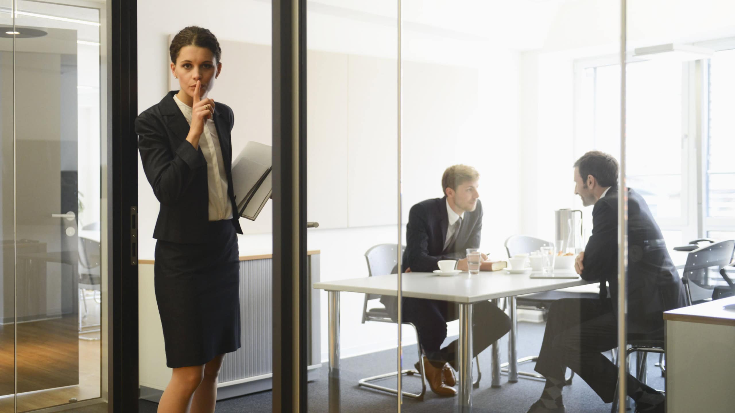 Businesswoman asking for quiet for colleagues in conference room