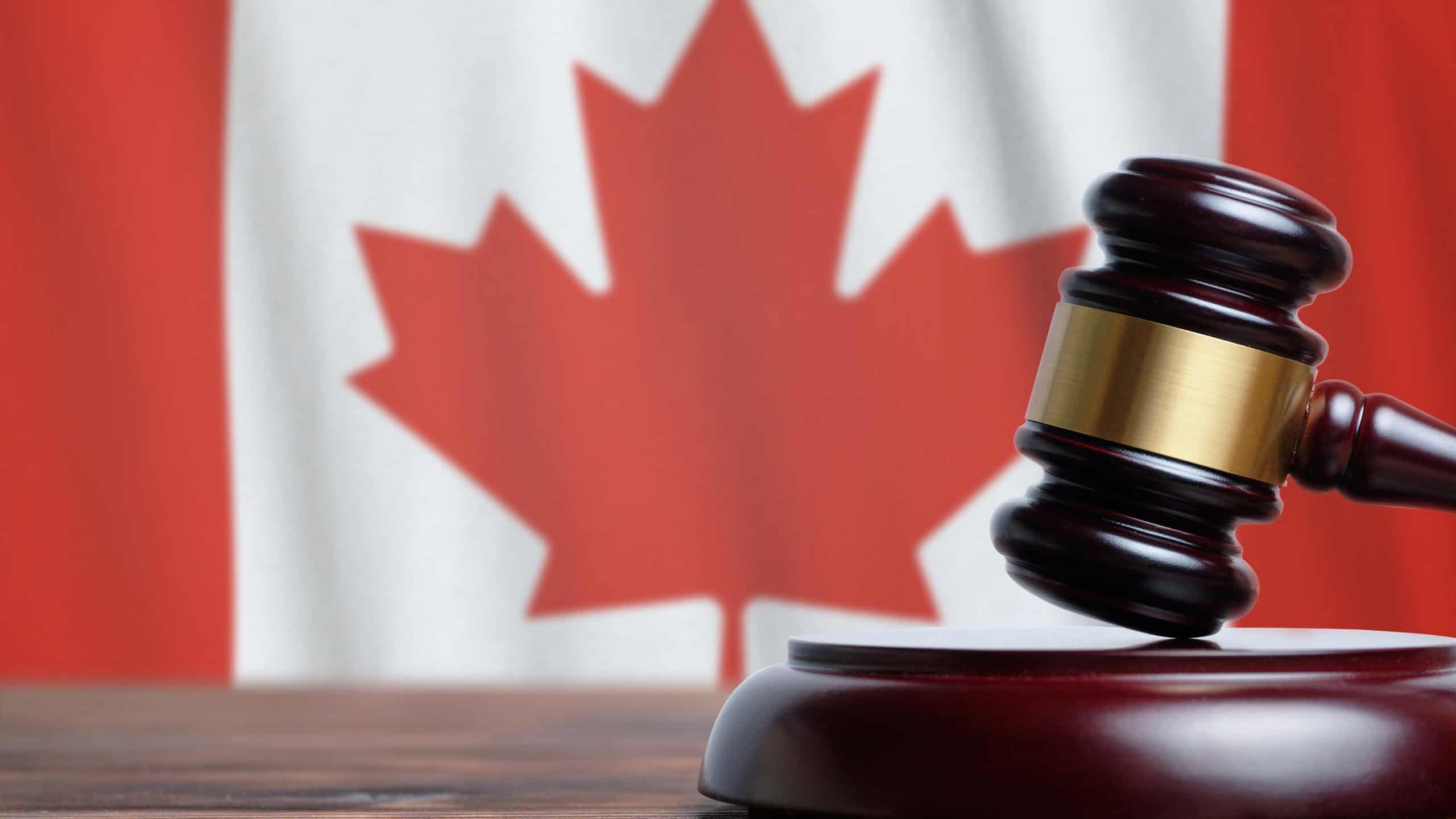 Justice and court concept in Canada. Judge hammer on a flag background.