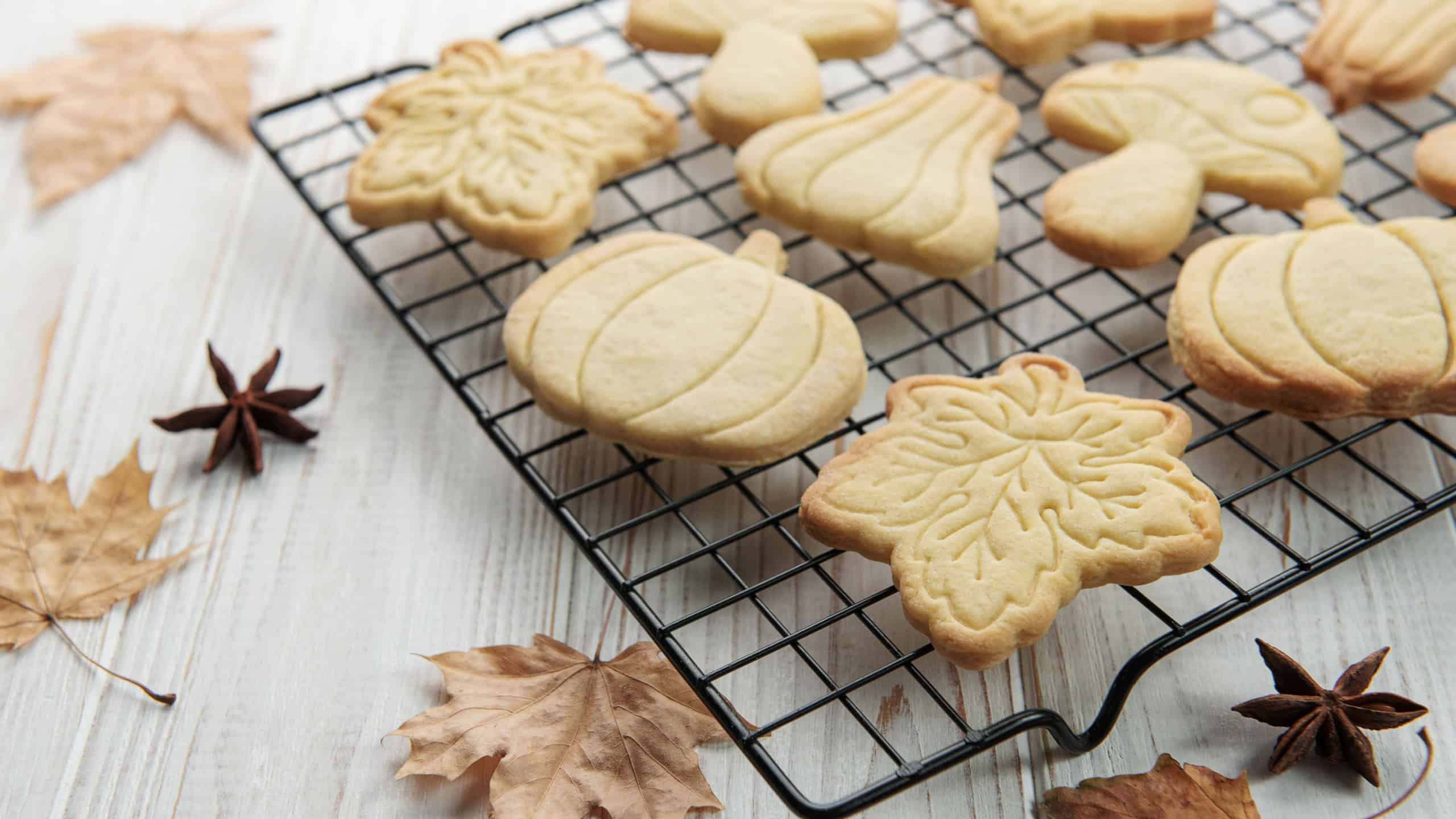 Autumn baking. Cookies in the form of pumpkin and leaves on the table. Cozy autumn concept.