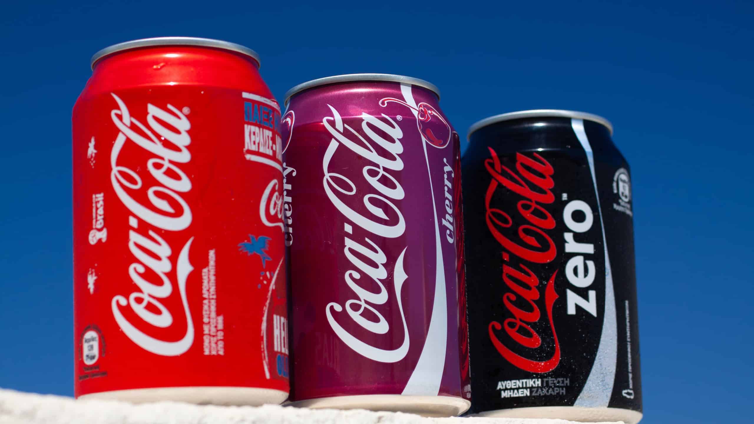 Greece, Rhodes, July 3, 2014 - Cool drink Coca-Cola in assortment. Three tin cans against the blue sky.