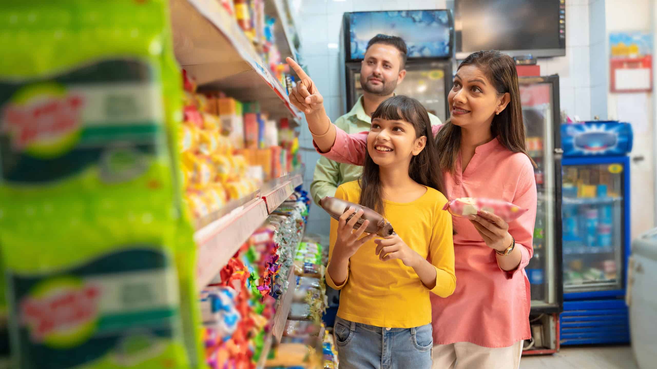 Indian family doing shopping together and choosing product at grocery shop