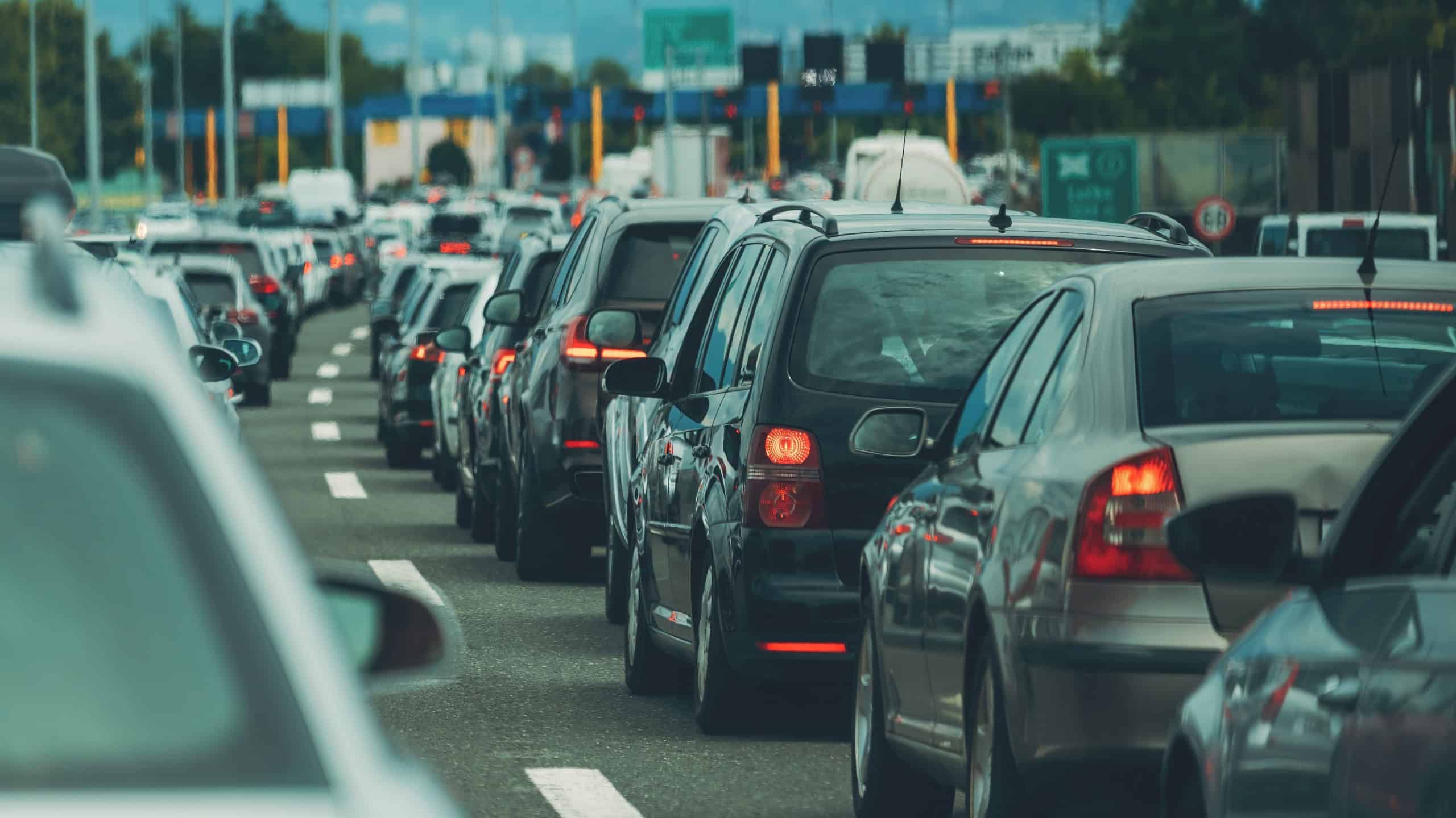 Large queue of vehicles on motorway pay toll in summer, selective focus