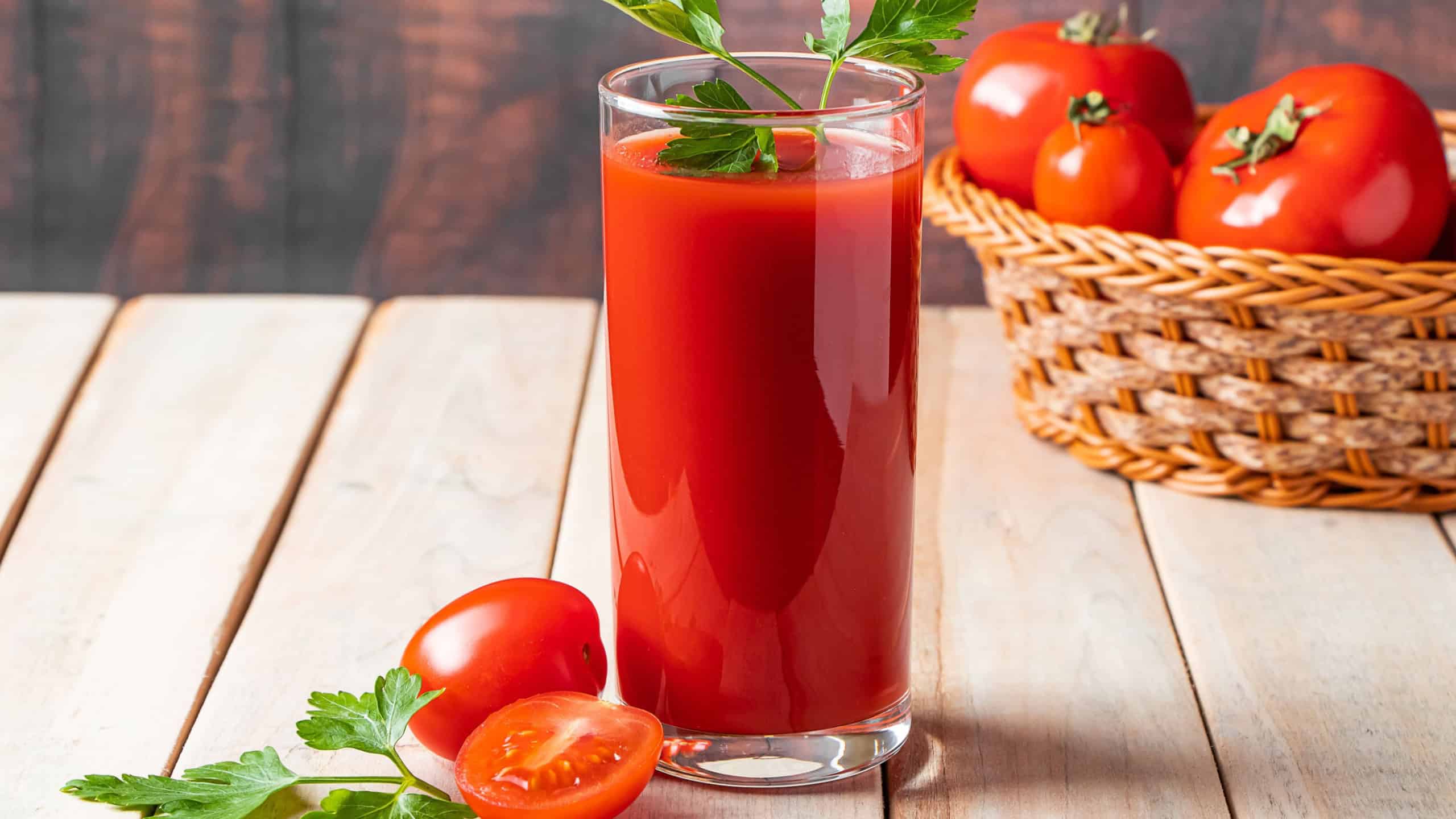 Diet tomato juice with parsley on a wooden background.