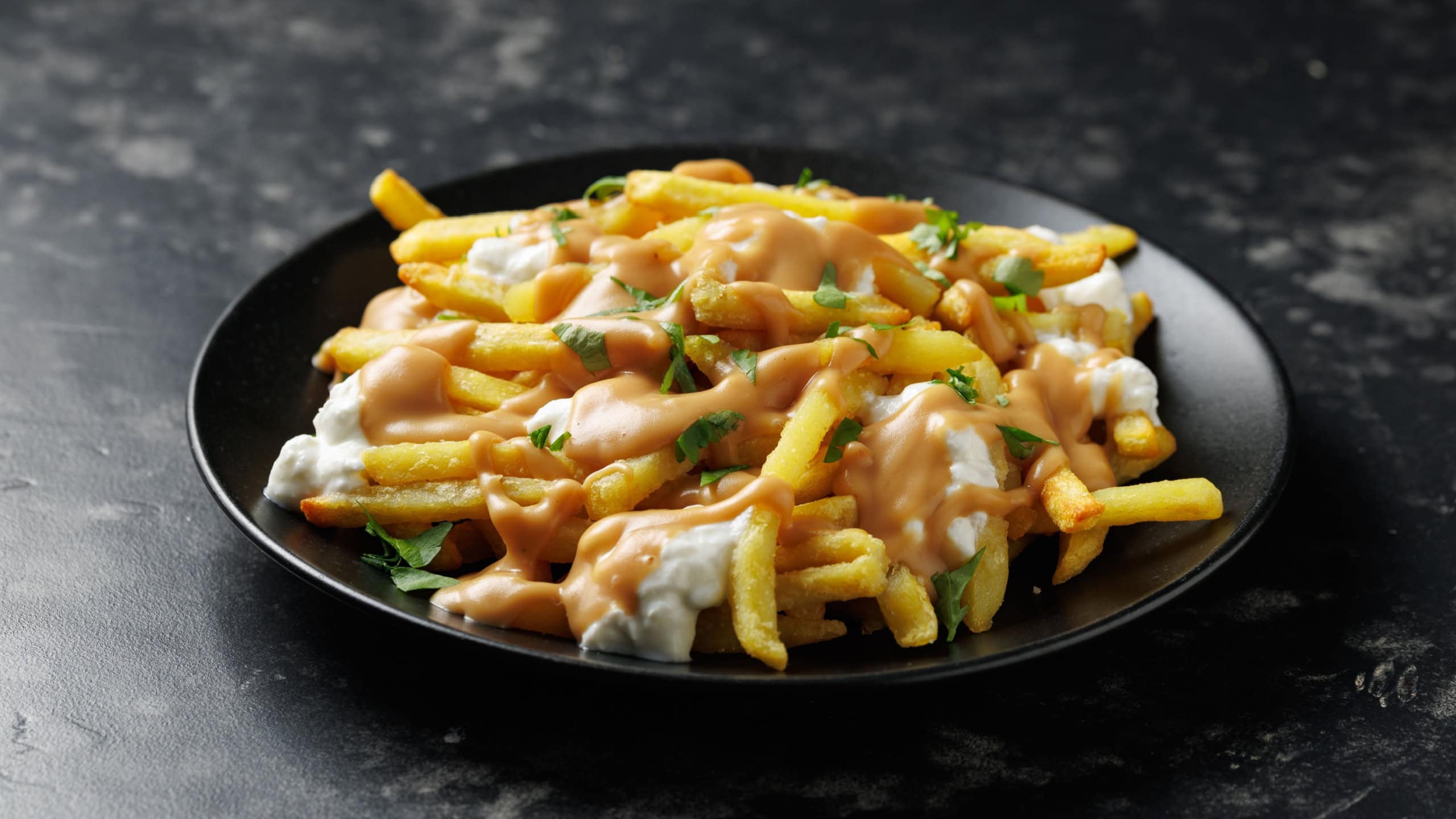 Delicious traditional canadian dish poutine gravy and fries with cheese. Rotating video.