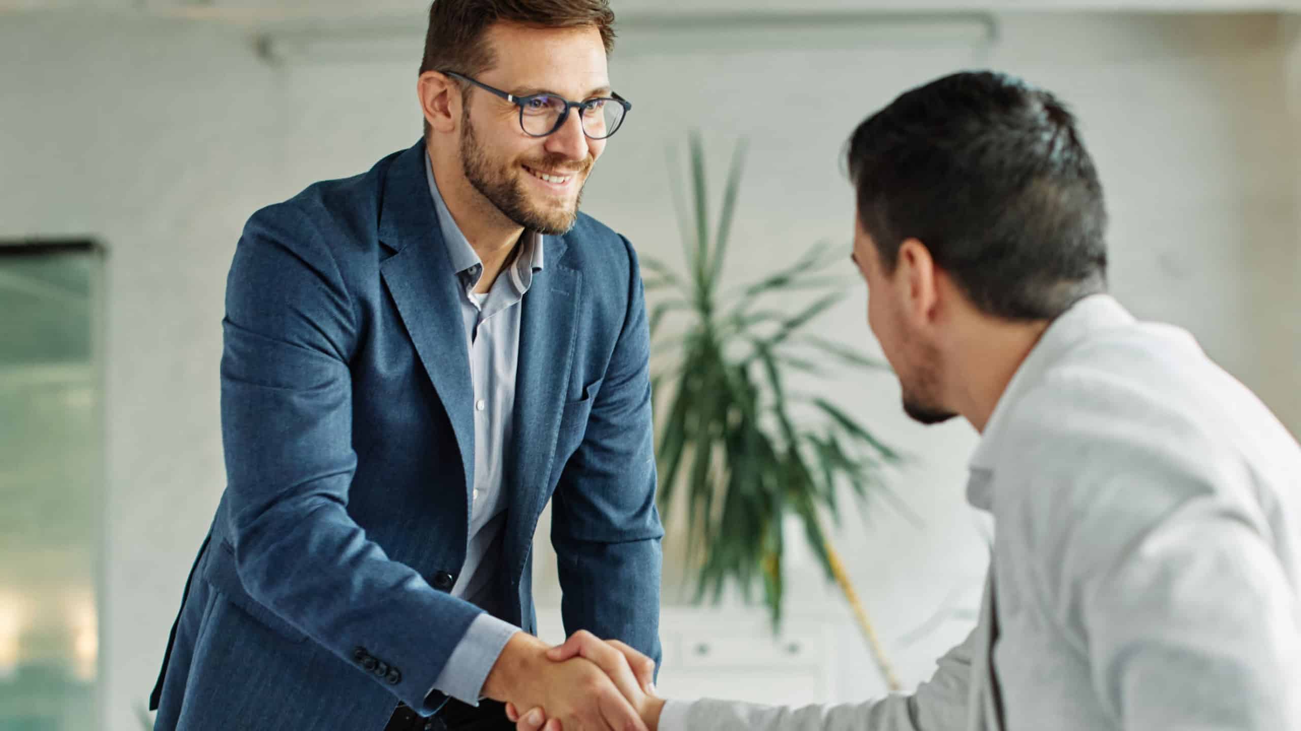 portrait of  a young businessman businessmen shaking hands introducing each other in the office 