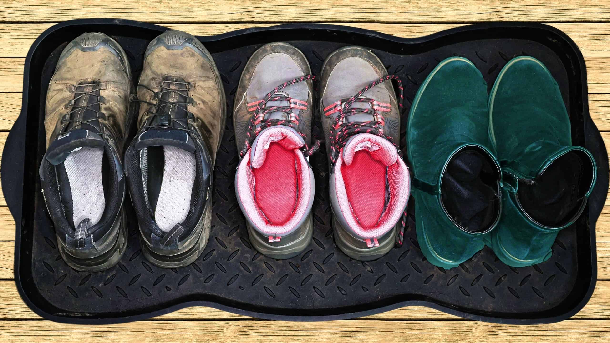 Pairs of muddy shoes on a floor tray