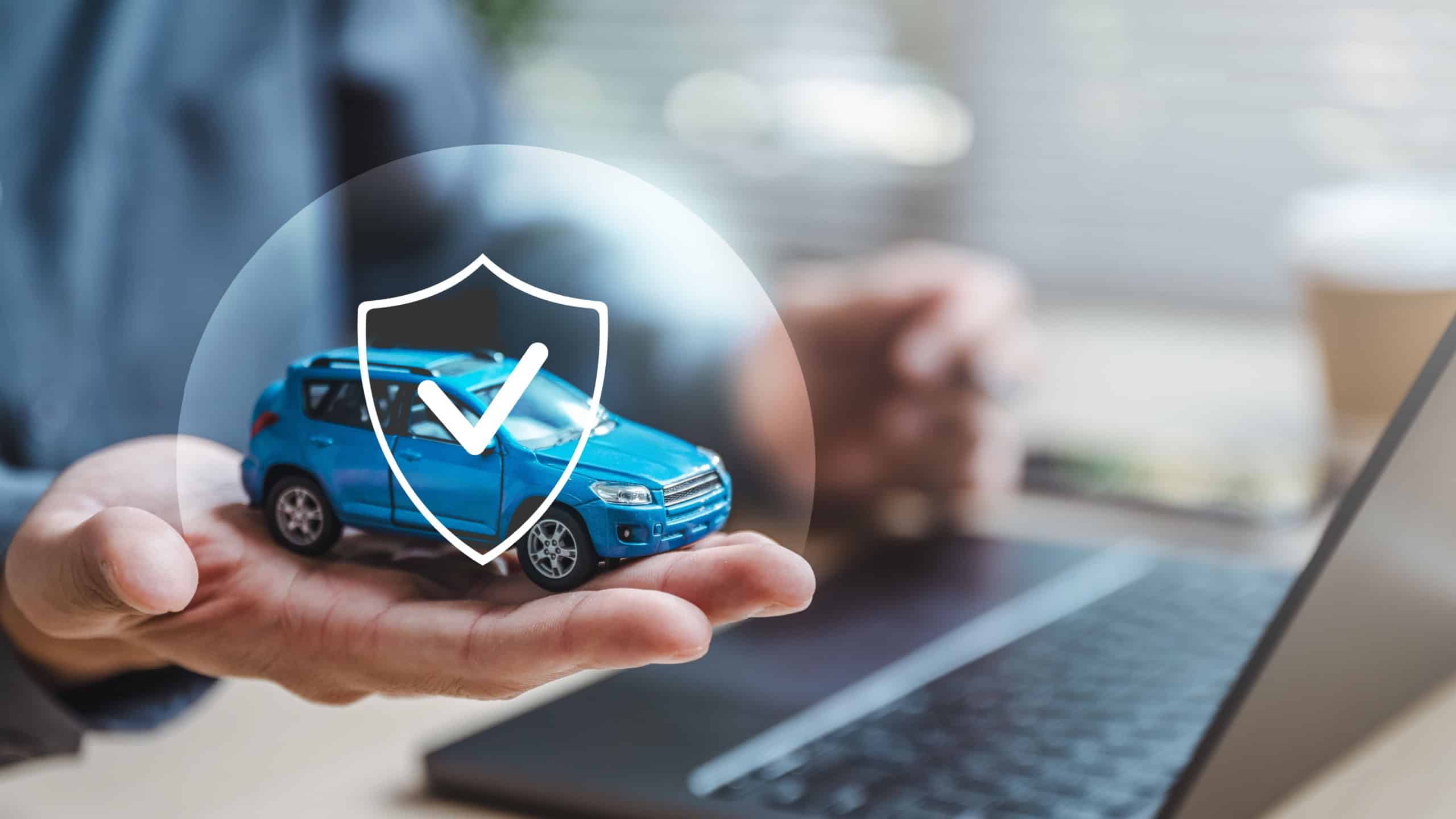 Car insurance protect safe transport. Safety trust. Protection secure assurance. A person is holding a blue toy car with a sticker that says protected on it. The car is placed on a laptop computer.