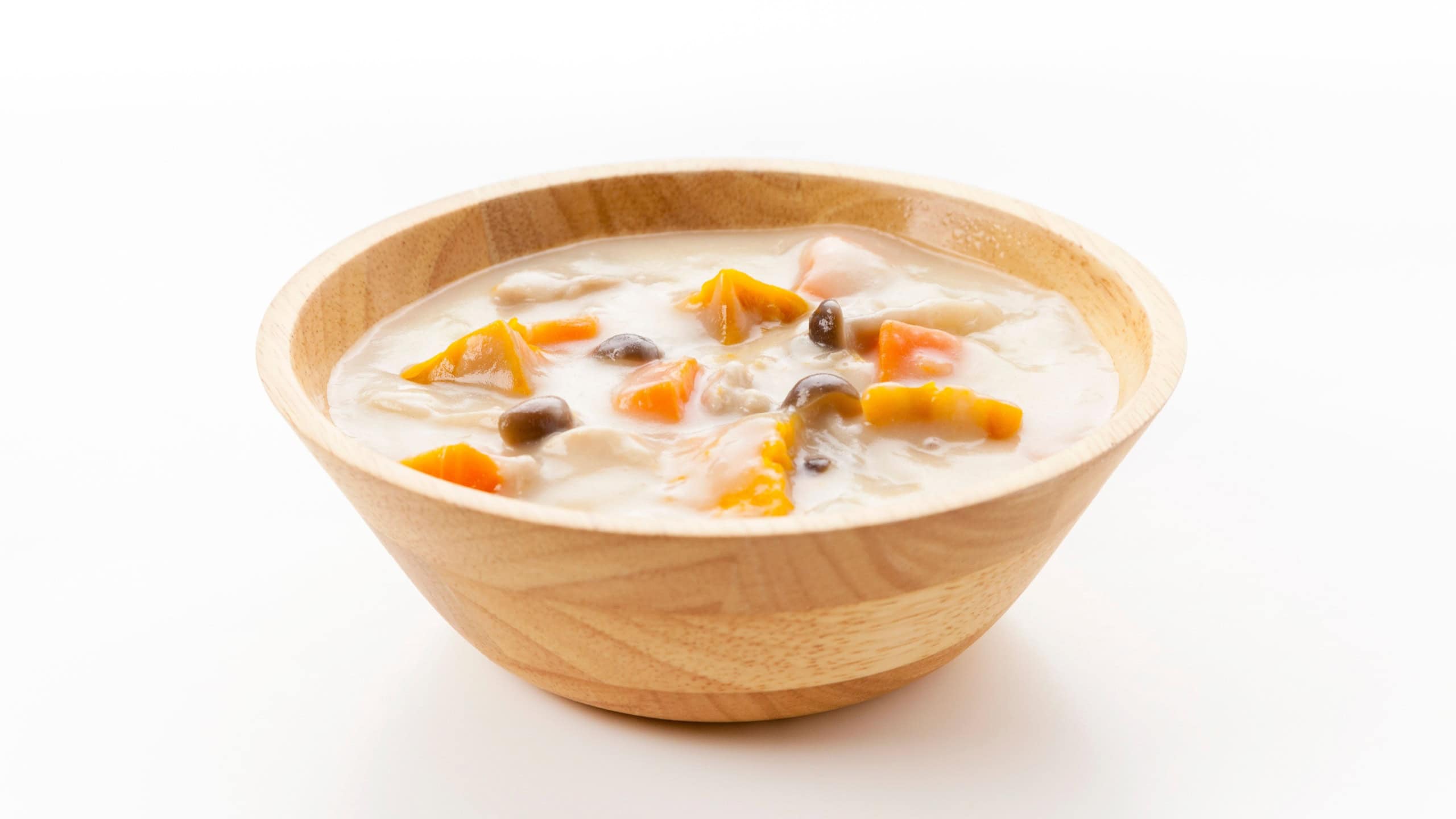 Creamy Chicken and Pumpkin Stew in a Wooden Round Bowl on White Background