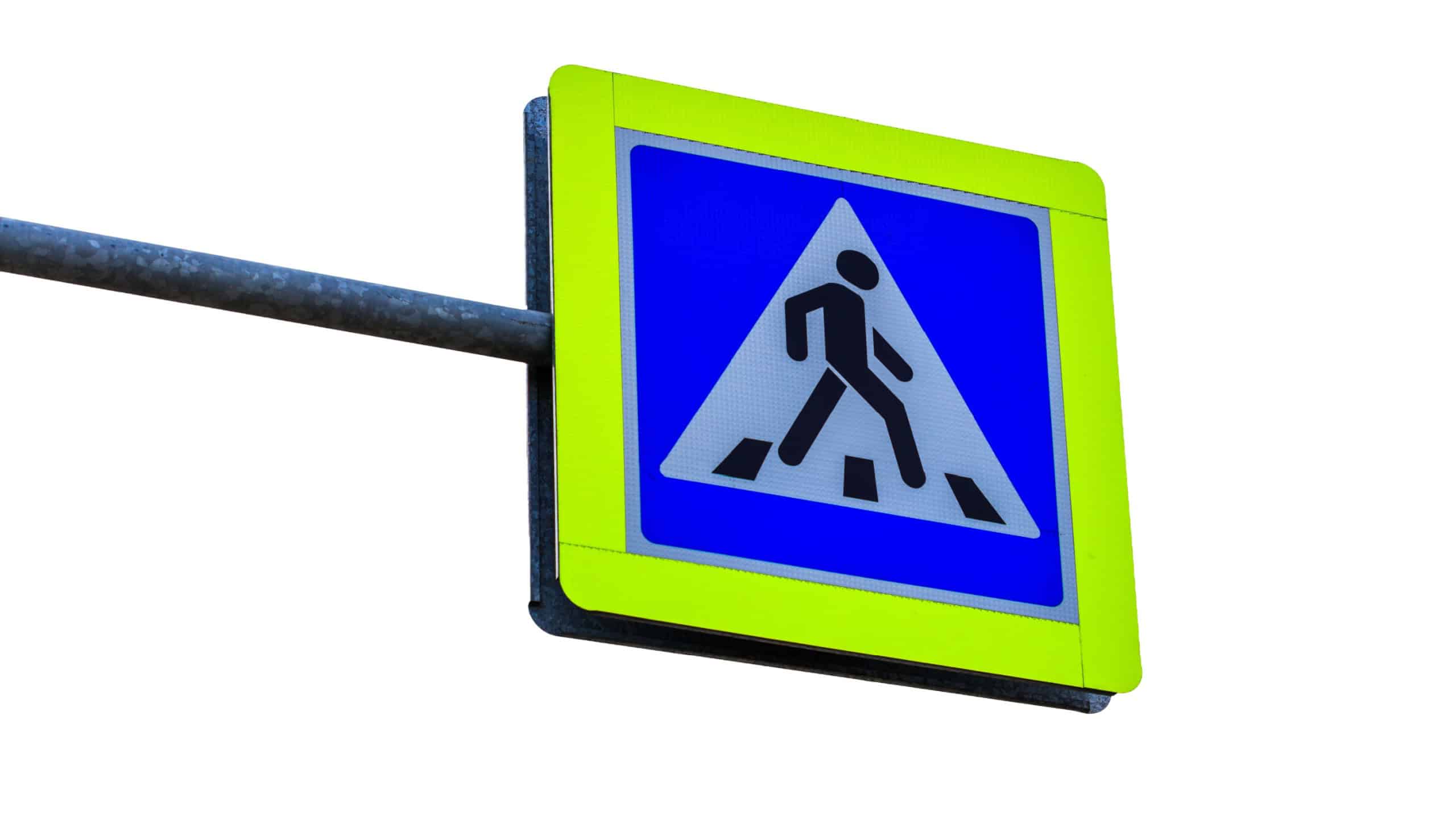 A blue and yellow pedestrian crossing sign on a street pole, perfect for traffic safety and infrastructure images.