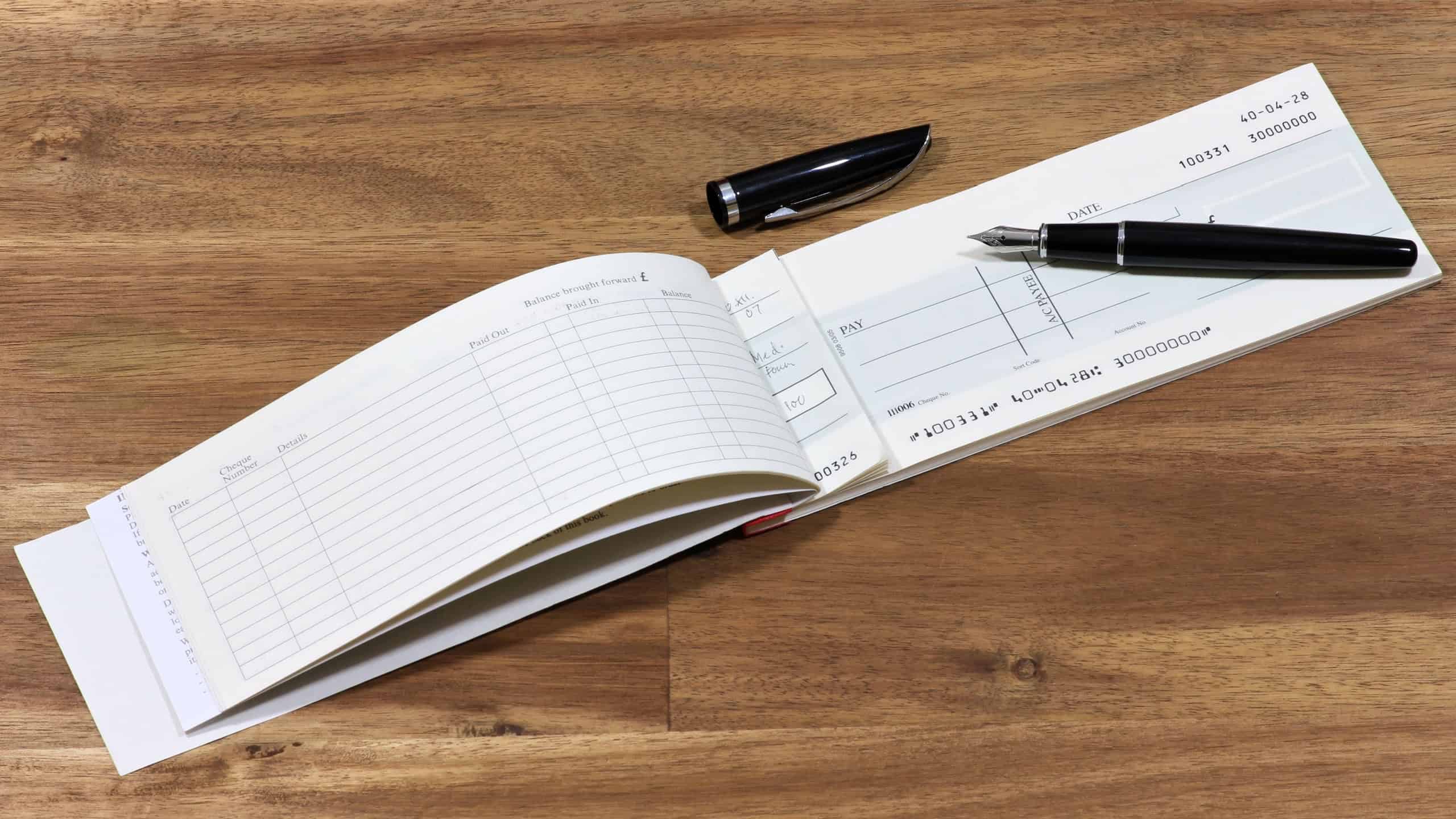 British checkbook on wooden desktop (account number is digitally altered and not real)