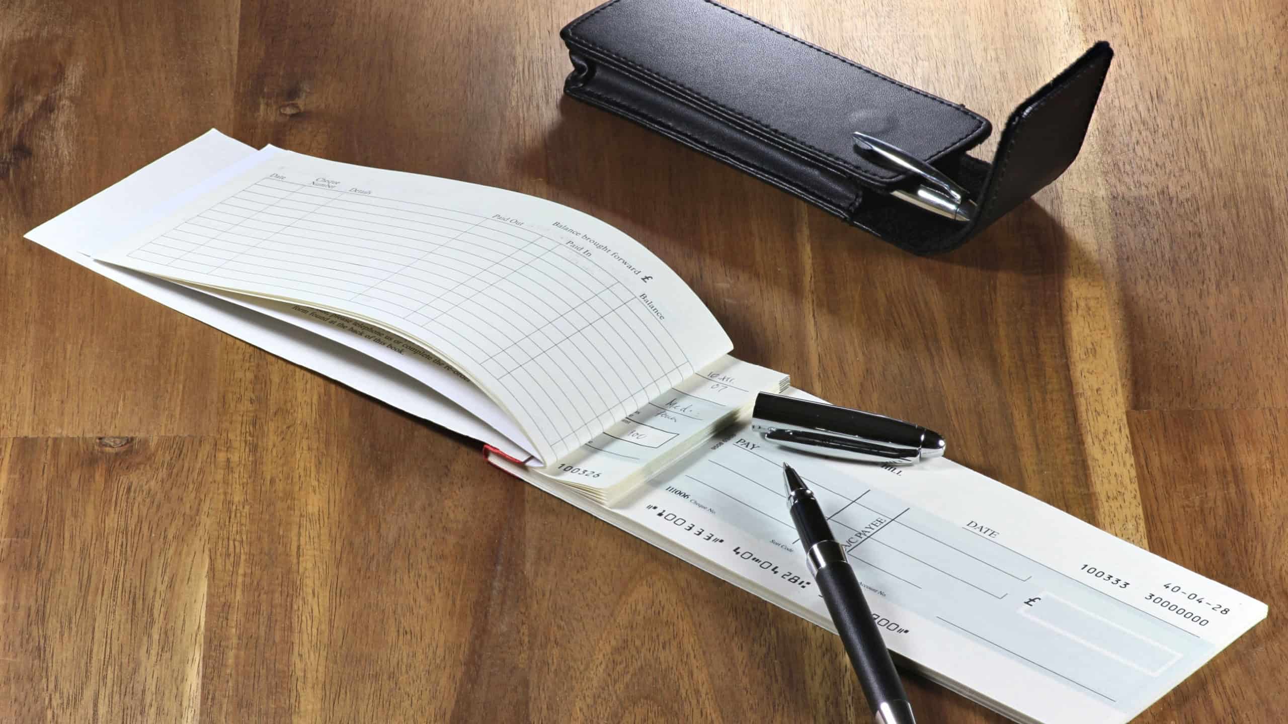 British checkbook on wooden desktop (account number is digitally altered and not real) 