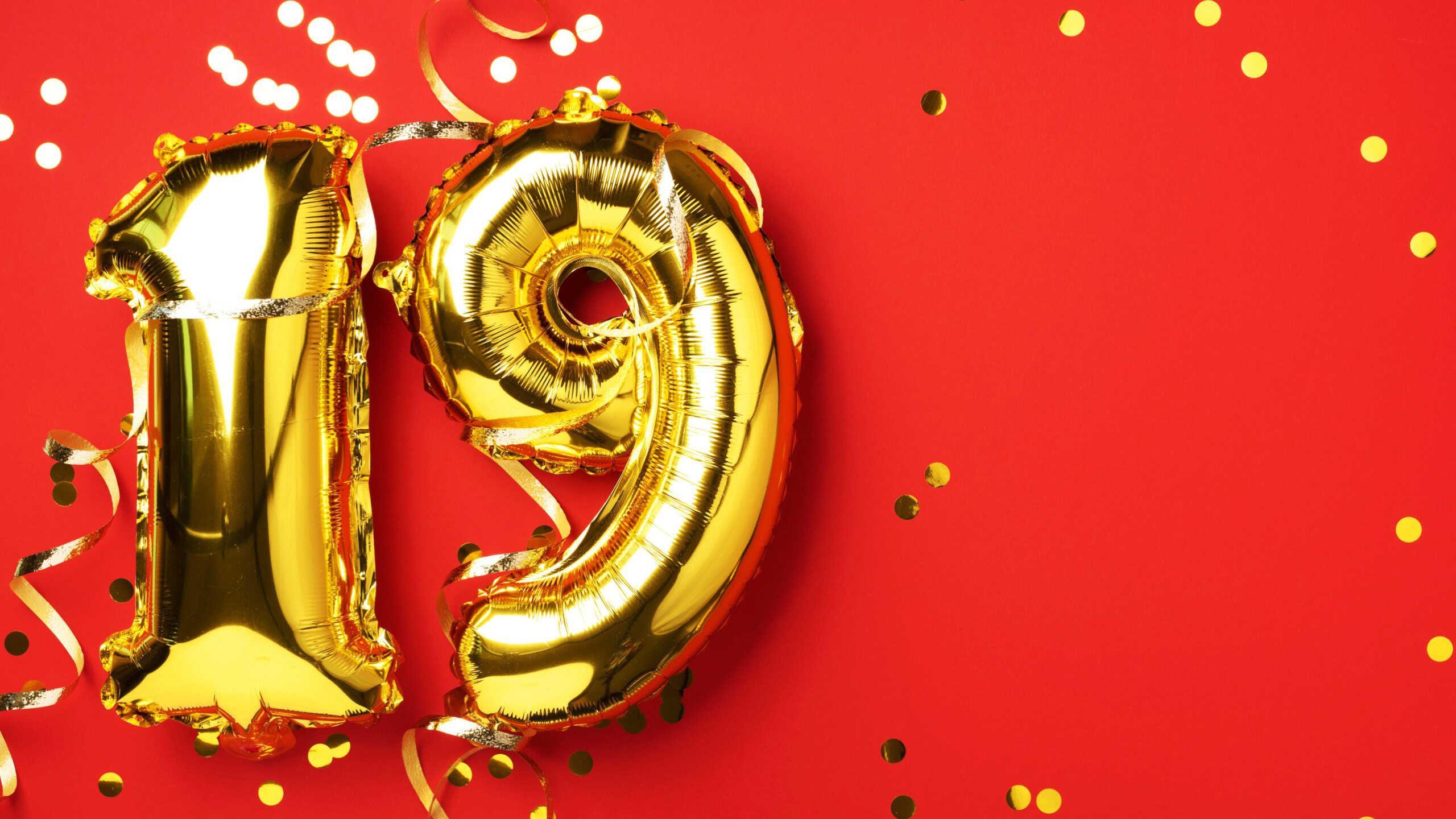 Gold foil balloon number, digit nineteen. Birthday greeting card, inscription 19. Anniversary celebration event. Banner. Stylish golden numeral, bright shiny glitter, red background. Numerical digit.