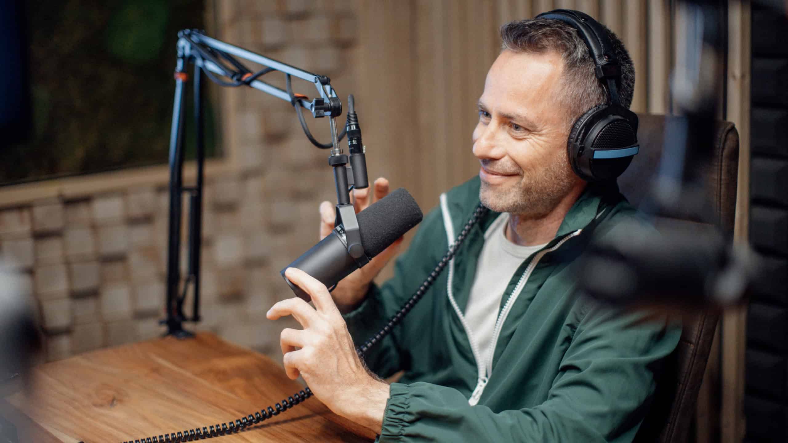 Portrait of mature radio host speaking in microphone while moderating a live show