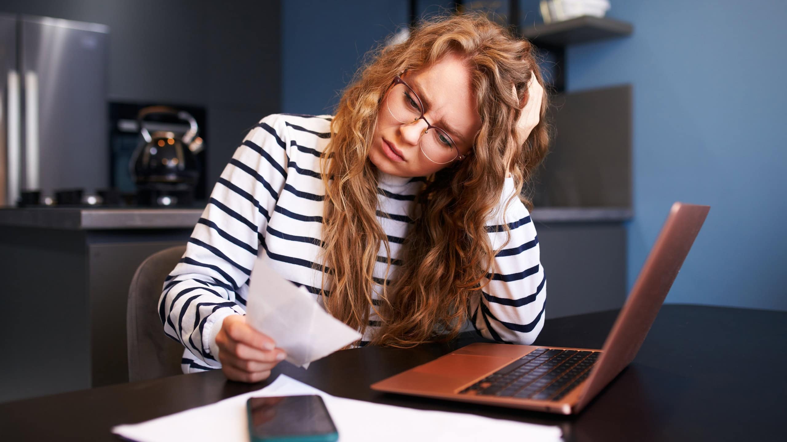 Unhappy woman calculates expenses on bills, upset about increased utilities prices. Female counting paychecks, debts, loans, reciepts to pay taxes. Inflation, financial crisis, low paying capacity.