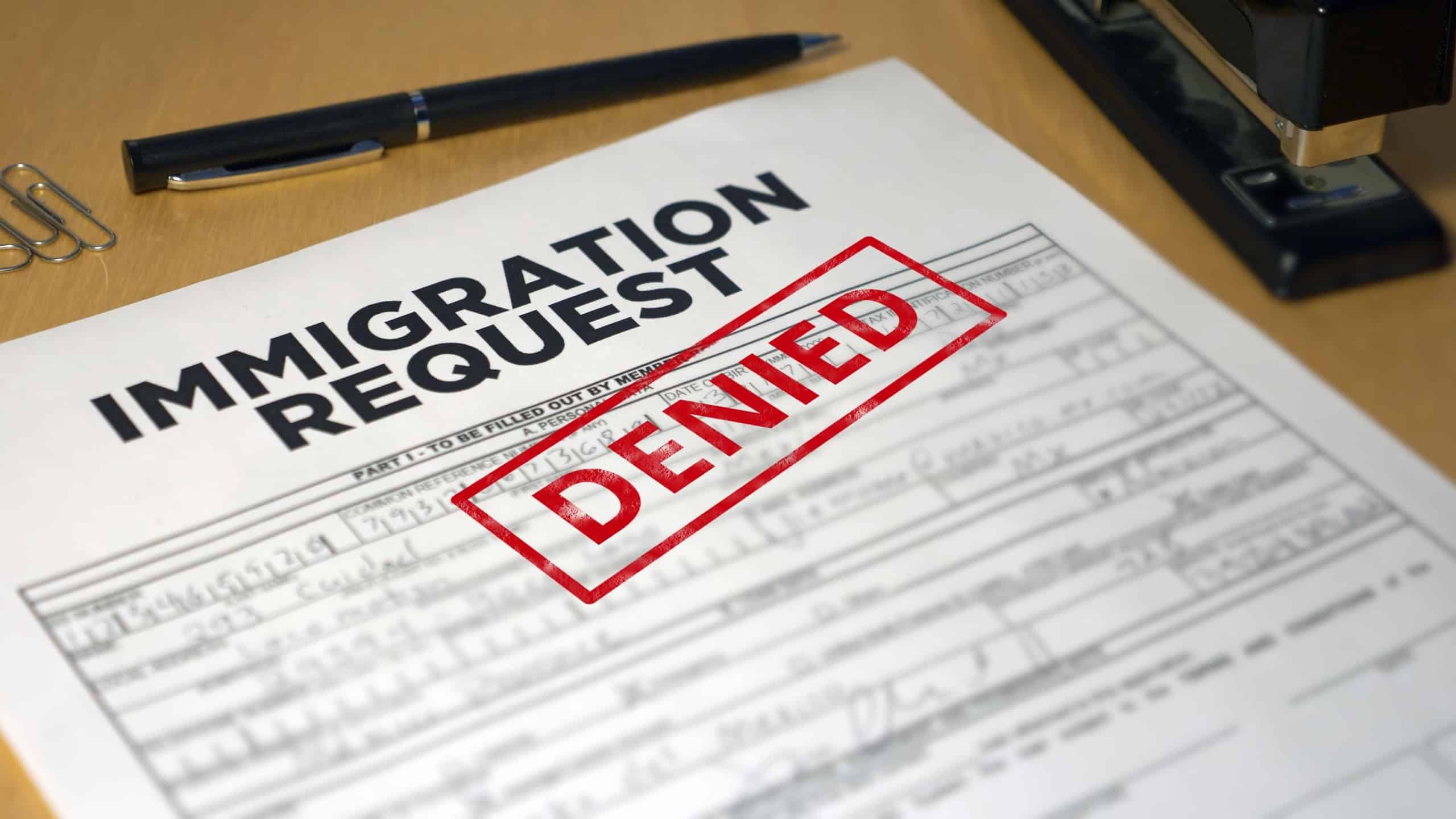 A closeup view of an immigration application getting denied. Data on form is fictional.