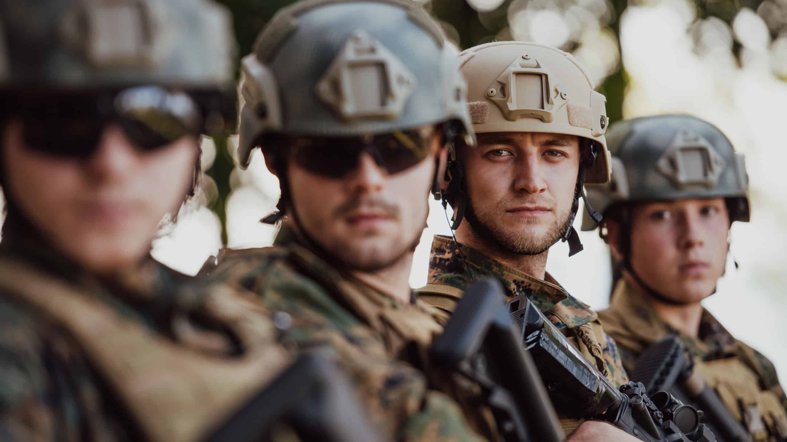 Soldier fighters standing together with guns. Group portrait of US army elite members, private military company servicemen, anti terrorist squad