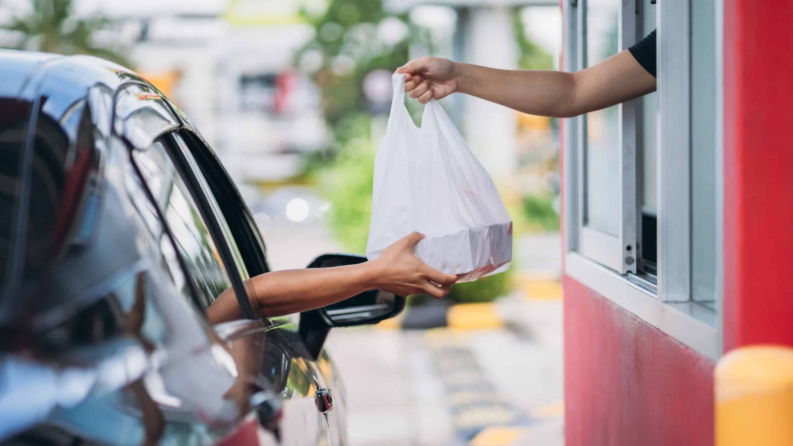 Young Man receiving coffee at drive thru counter