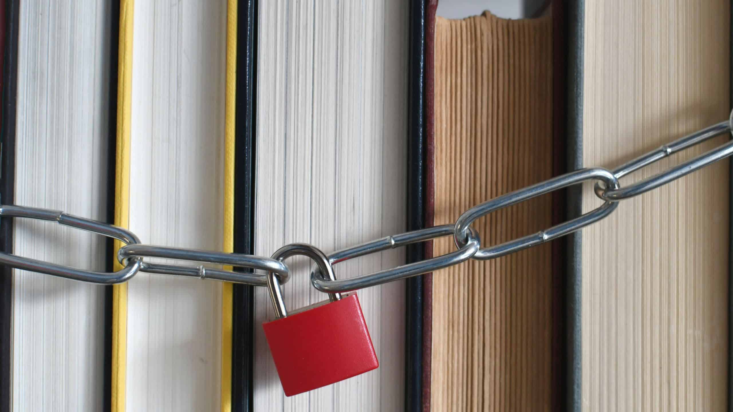Padlock and chain around a stack of books - concept for banned book, censorship