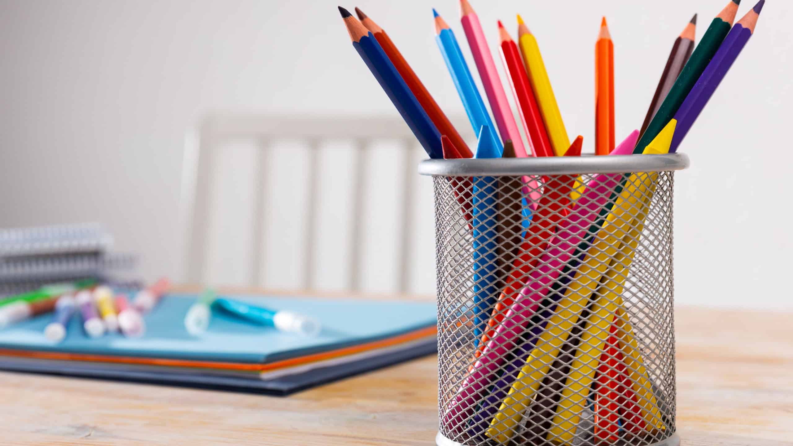 Pen pot with pencils, globe and school office stationery on table