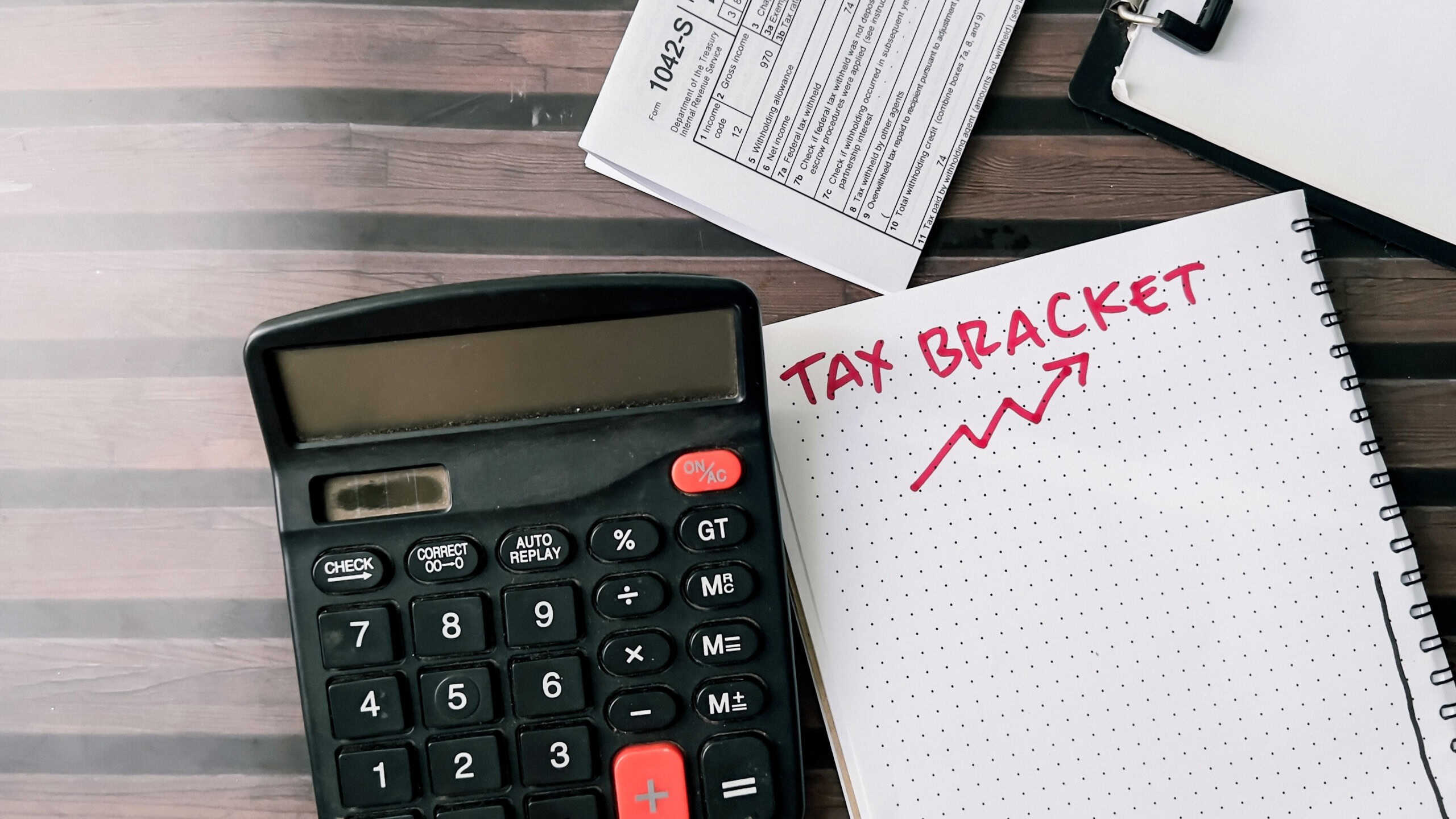 Concept of Tax Bracket write on book isolated on Wooden Table.