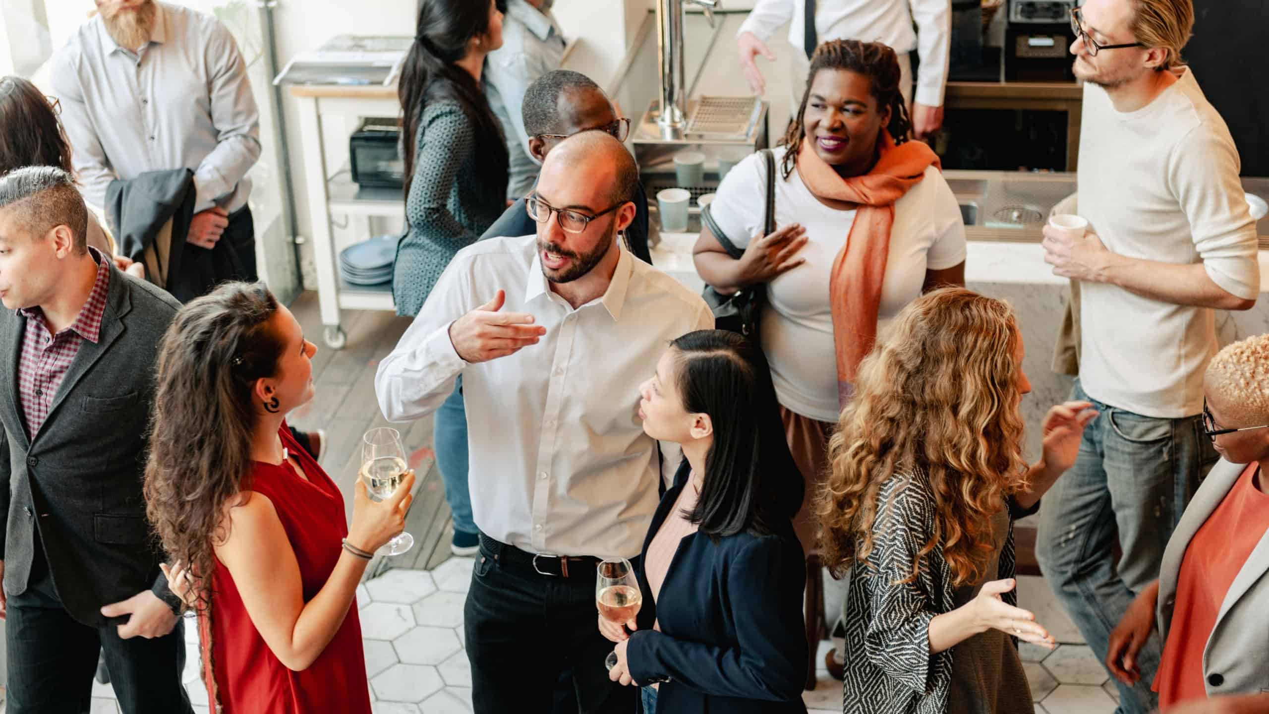 Diverse group of people at social event, mingling and chatting. Diverse crowd enjoy drinks and conversation in lively social gathering party. Social event with diverse group of people mingling