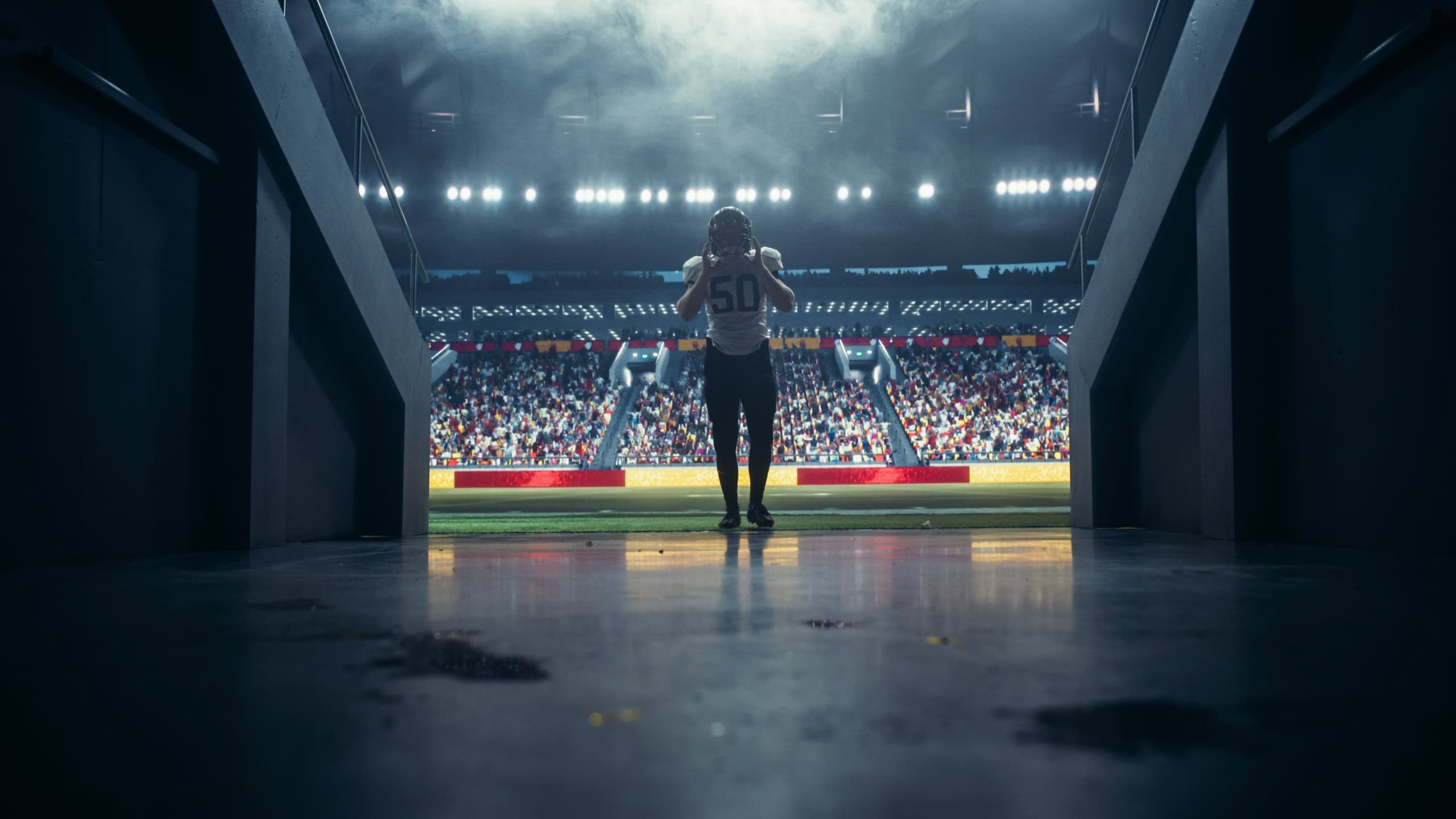 Portrait of a Professional Footballer in White Uniform Walking Away From a Stadium in a Tunnel. Best Player is Celebrated by a Full Arena of Sports Fans in a Big Outdoors Stadium