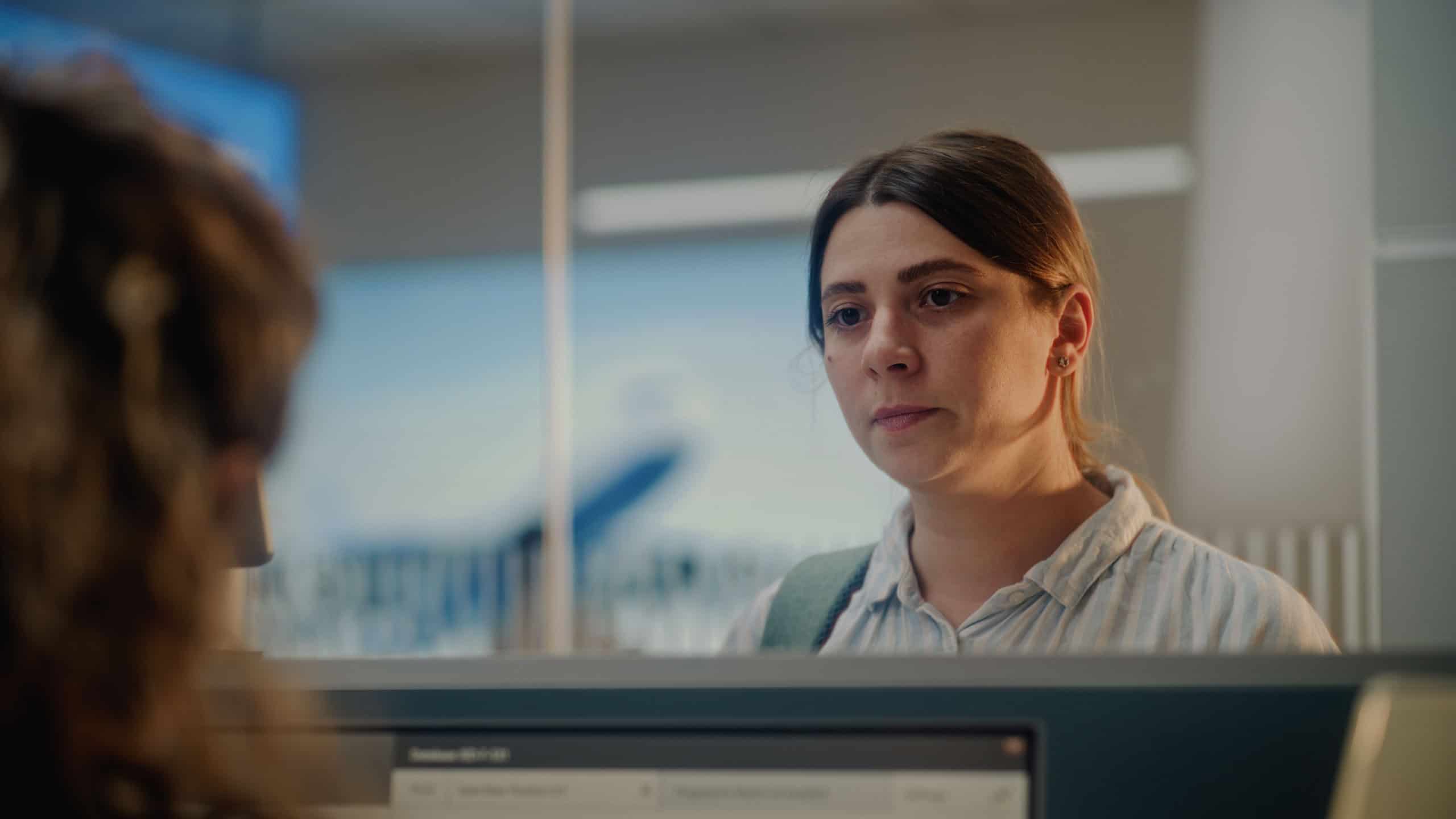 Close Up of Woman Waiting for Passport Control at Airport Check-in Counter. Female Airline Agent Giving Documents and Boarding Pass to Passenger for Flight. Tourist in International Airport Terminal.