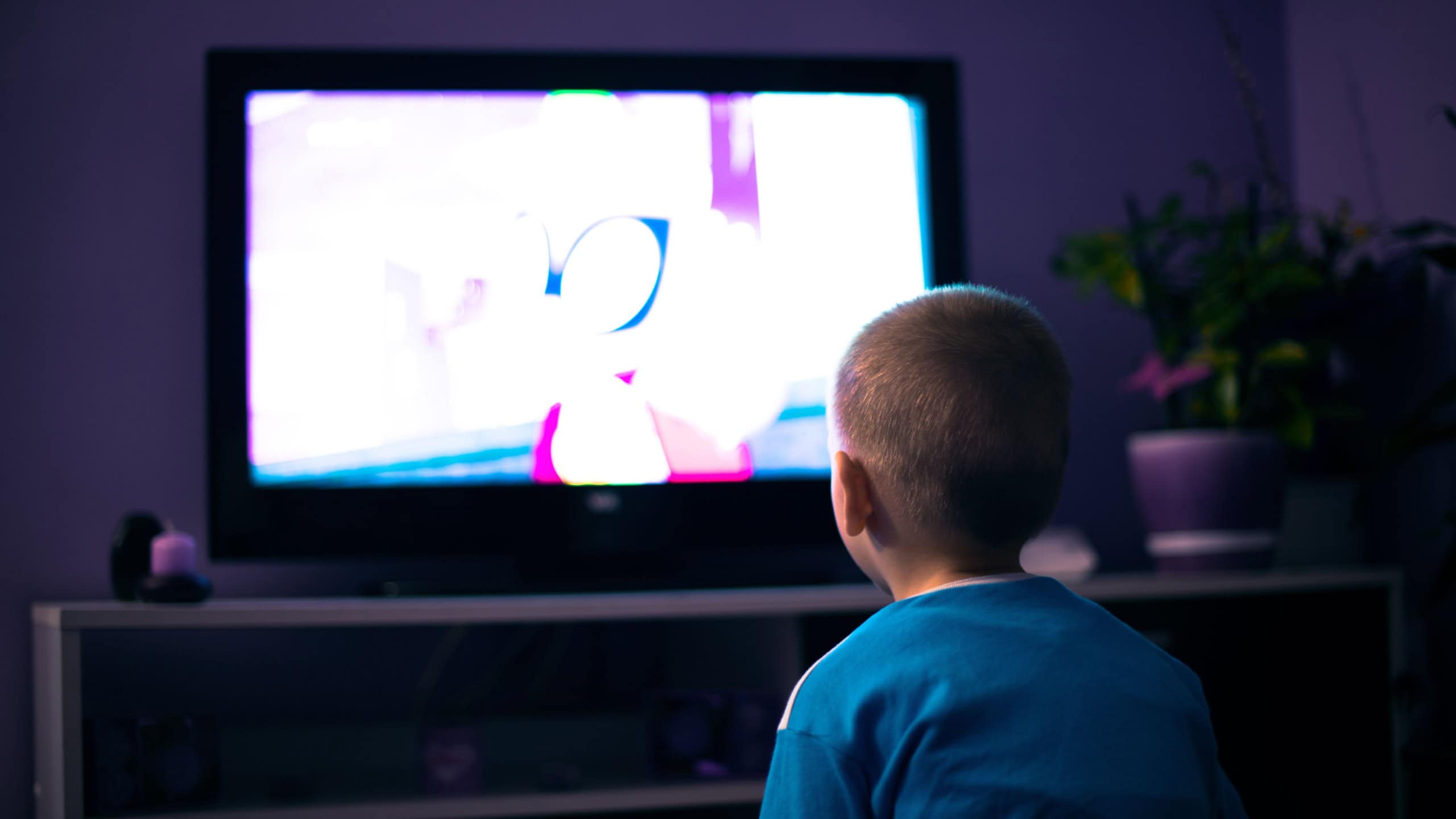 Boy watching television in dark living room