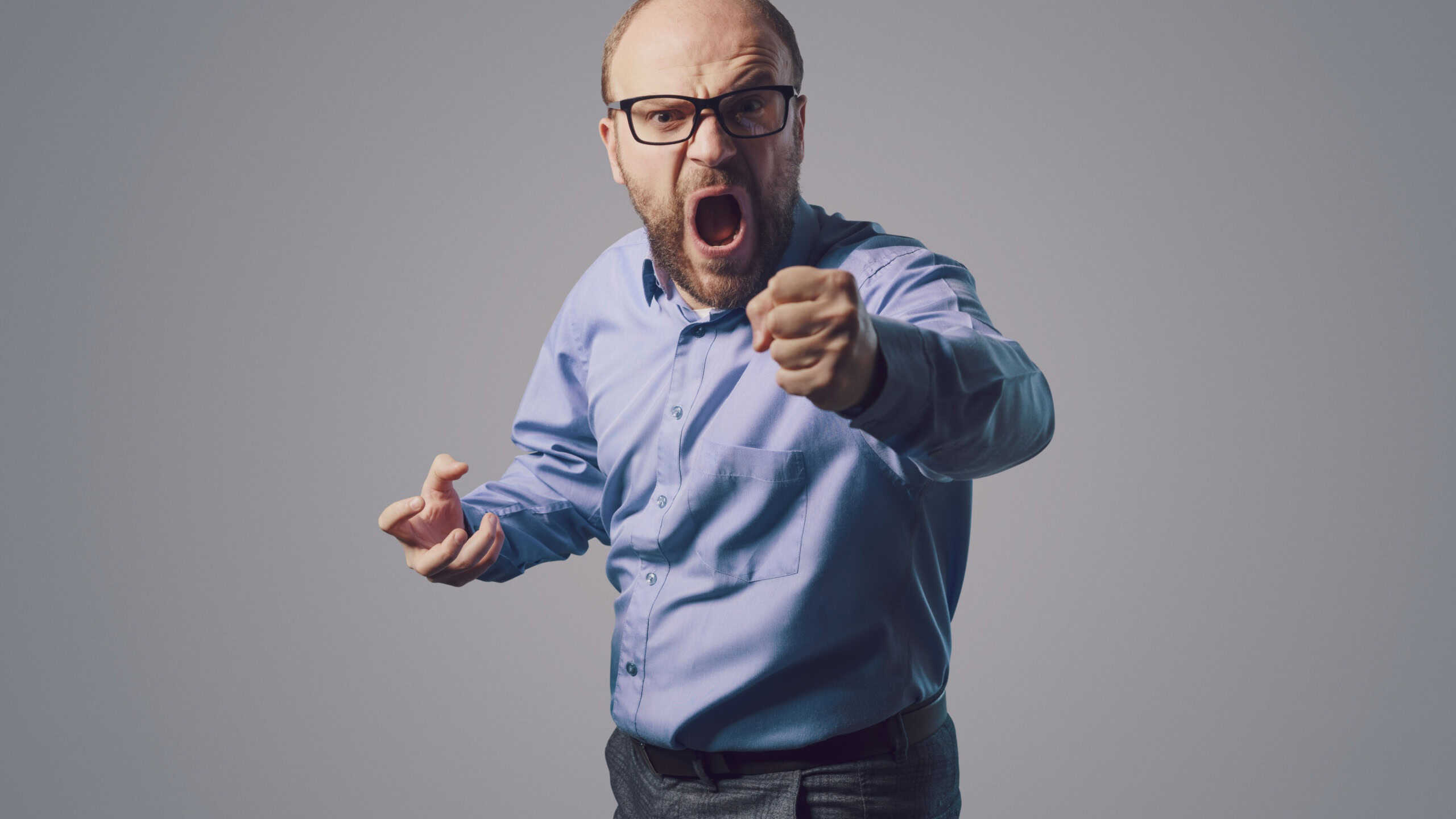 Angry businessman shouting at the camera, he is stressed and disappointed