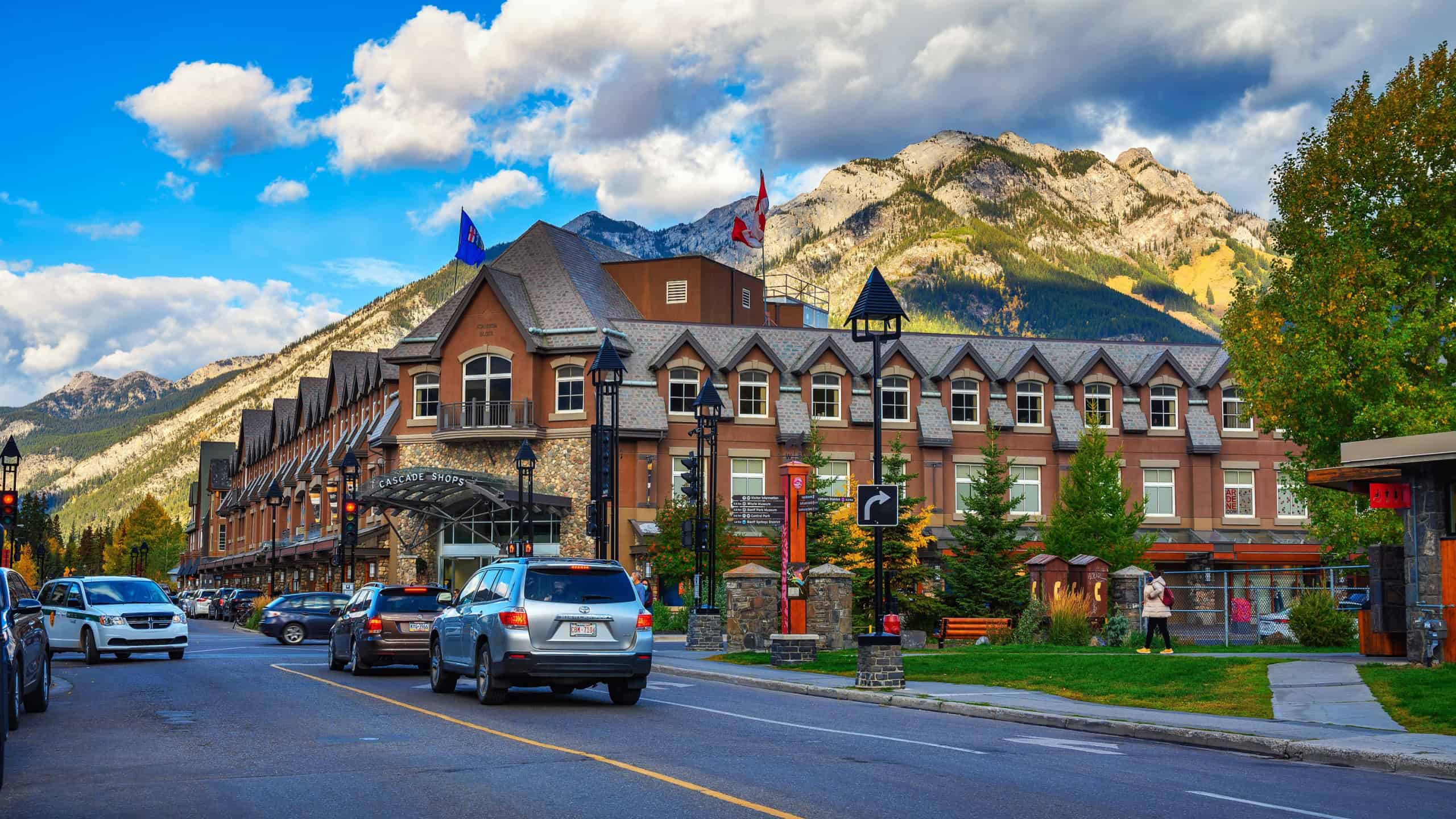 Banff, Alberta, Canada - September 26, 2021 : Scenic street view of Banff with cars and Cascade Shops Shopping Mall. Banff is a resort town and popular tourist destination.