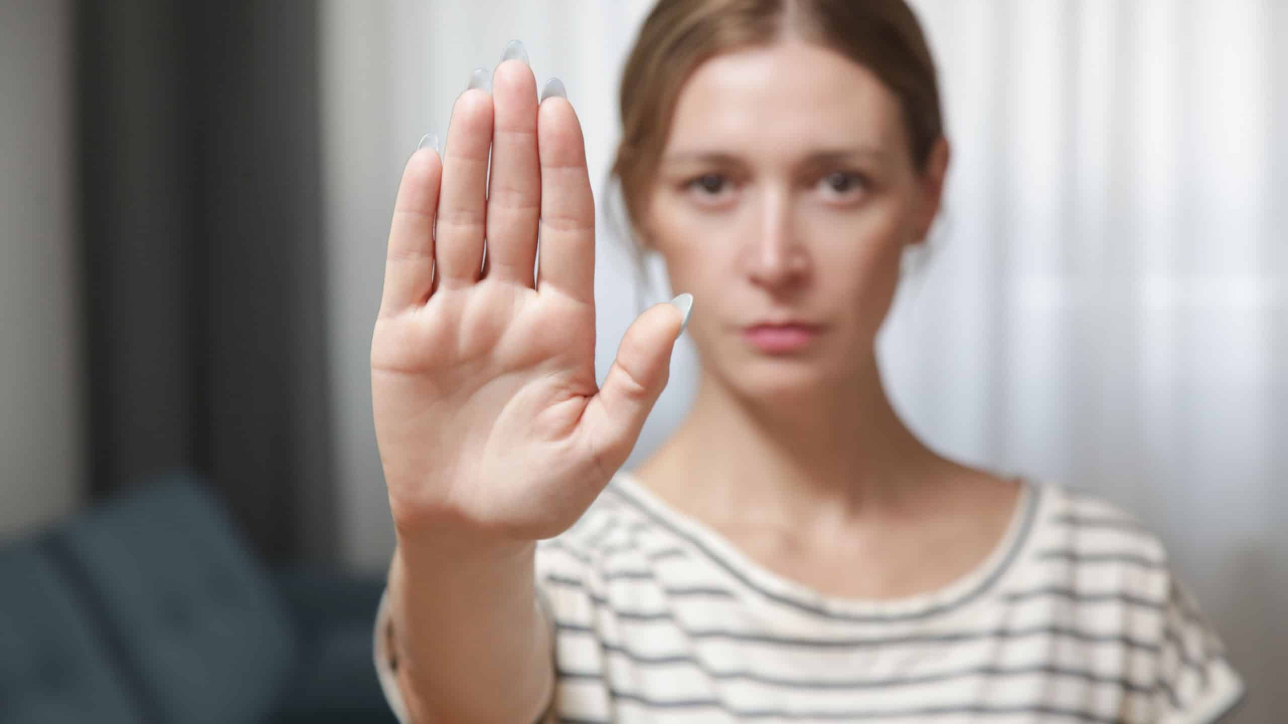 Serious worried young woman making hand stop gesture expressing fighting for equal rights against domestic violence, abuse, discrimination, bullying, sexual or racial discrimination.
