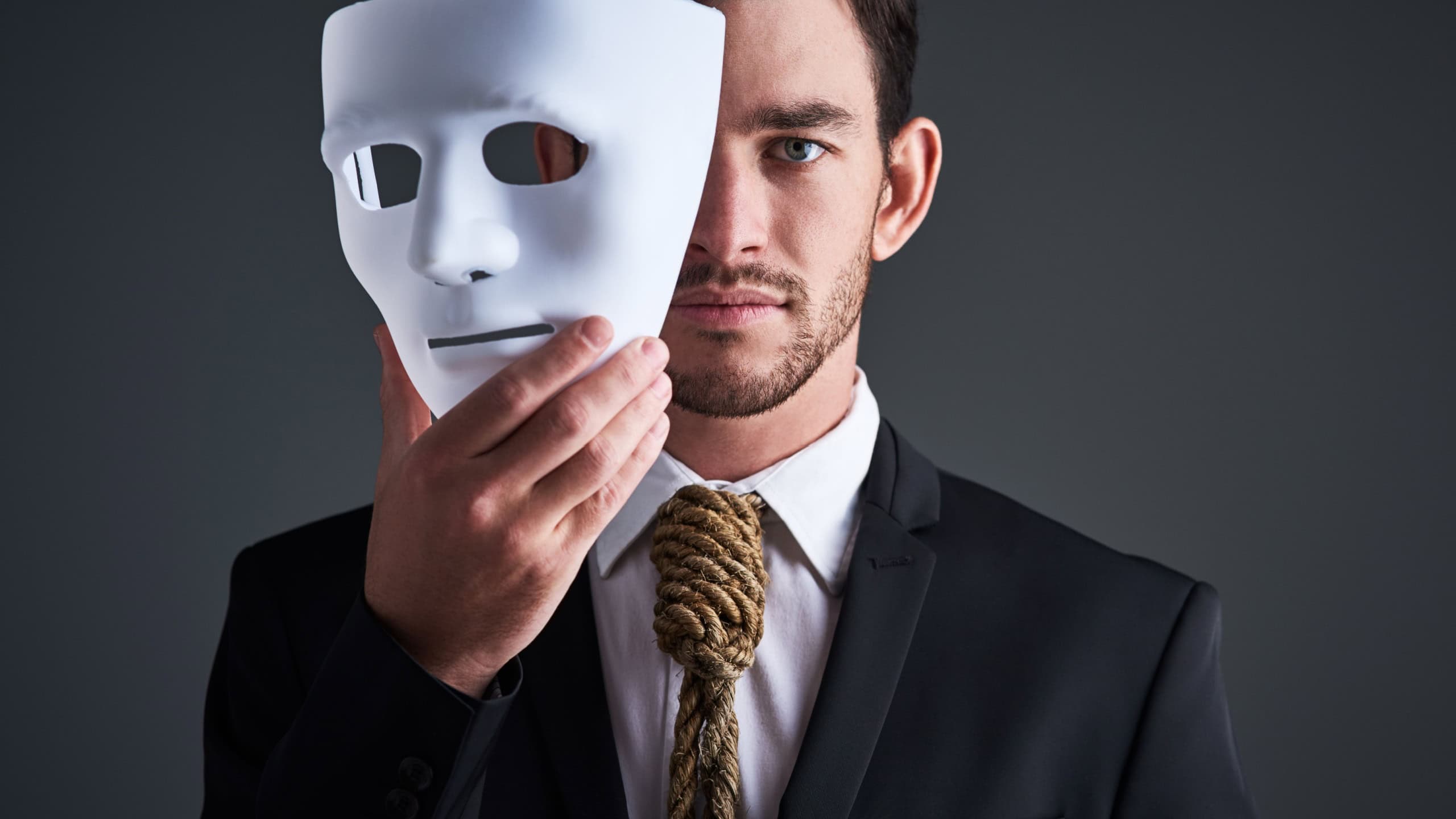 Two faced portrait, mask and fake businessman in a studio with serious face with secret personality. Manager and corporate male with rope tie showing corporate slavery and control in business suit