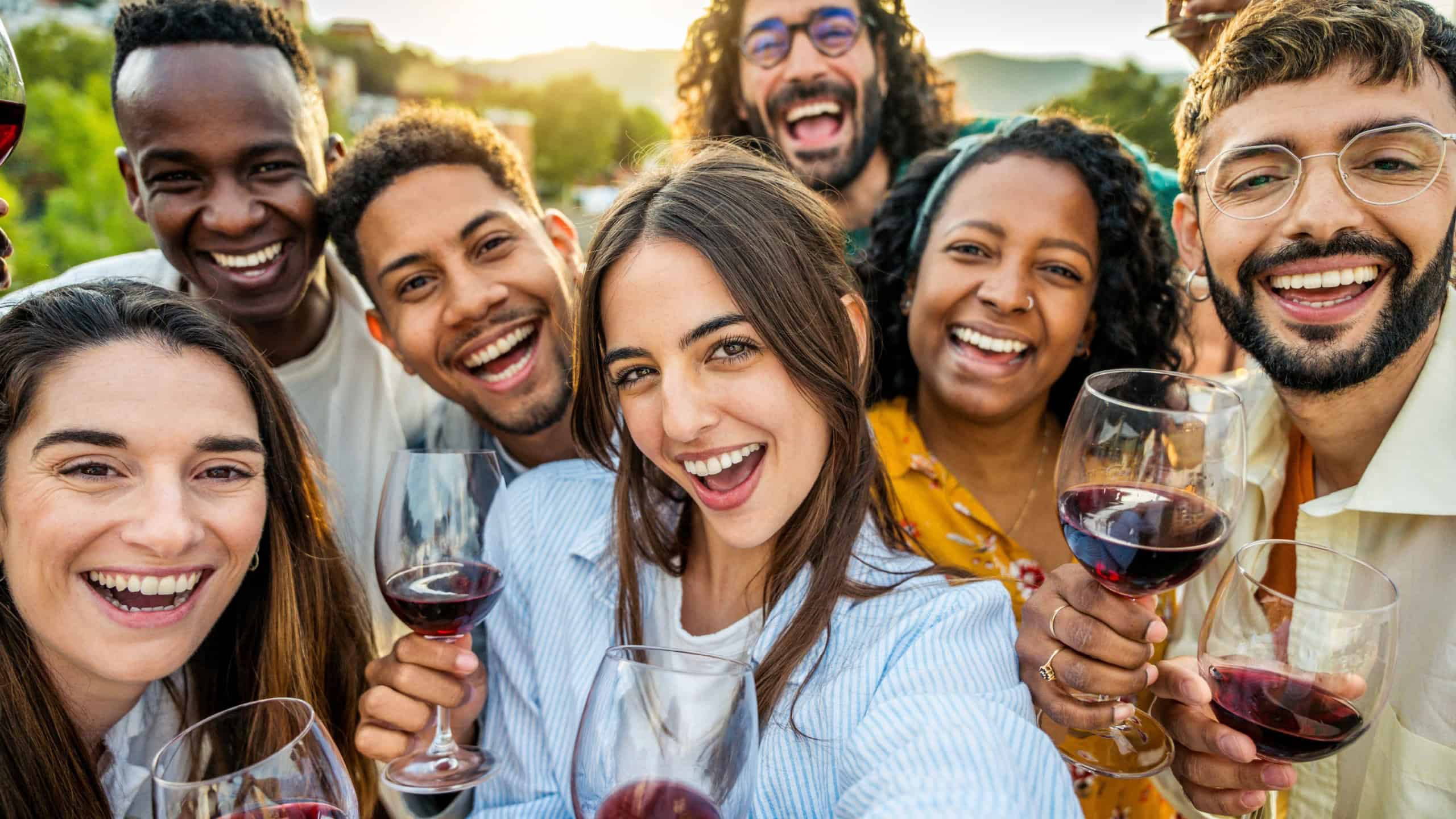 Multiracial friends drinking red wine outside at farm house vineyard countryside - Group of young people taking selfie picture outdoor - Life style concept with guys and girls enjoying summer vacation